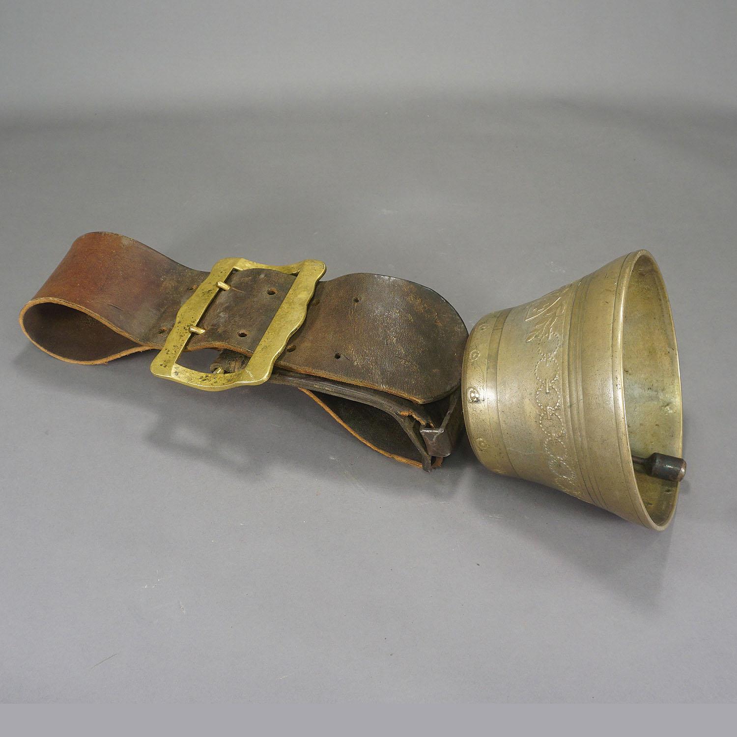 A great casted bronze cow bell from the alps region of Switzerland. The antique bell was manufactured around 1900 and features floral high relief motifs and foundy mark. The bell still has its original brown leather strap with buckle. These bells