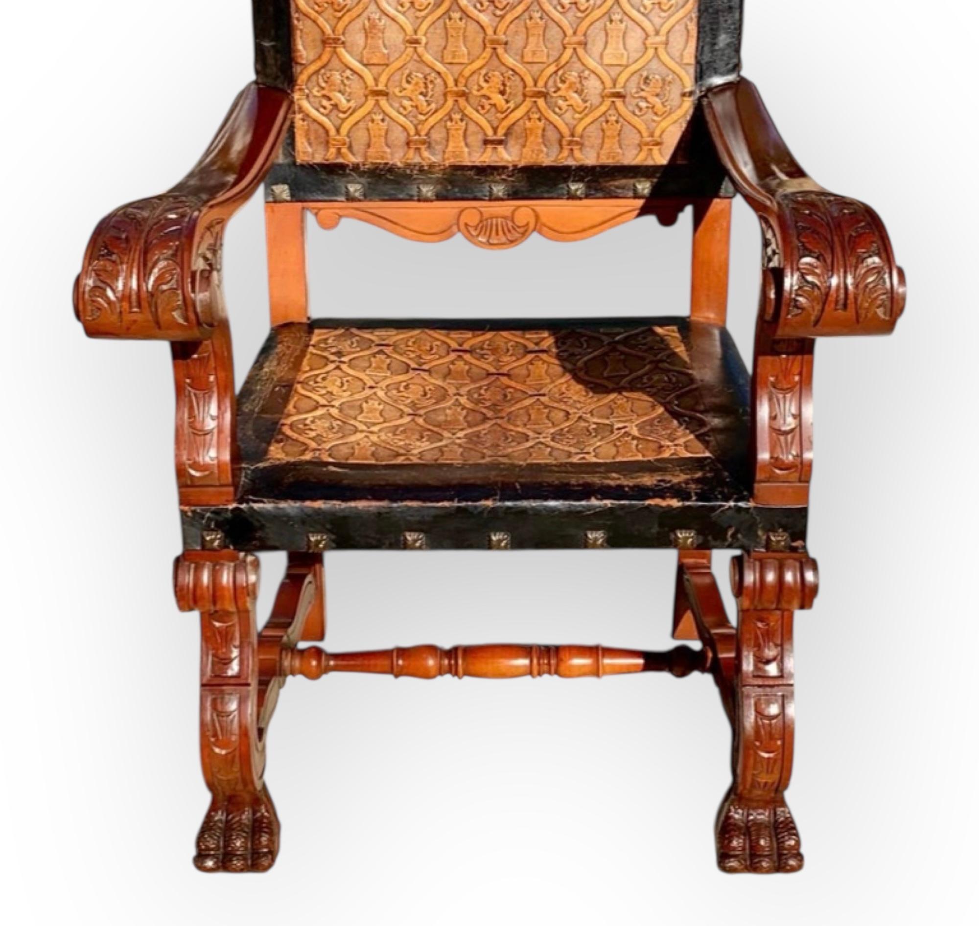 Ancien fauteuil castillan en acajou sculpté à la main et en cuir délicieusement gaufré, avec un beau profil sculpté d'un Conquistador espagnol dans la partie supérieure de la crête. Les bras sont sculptés de feuilles d'acanthe et les pieds de pattes