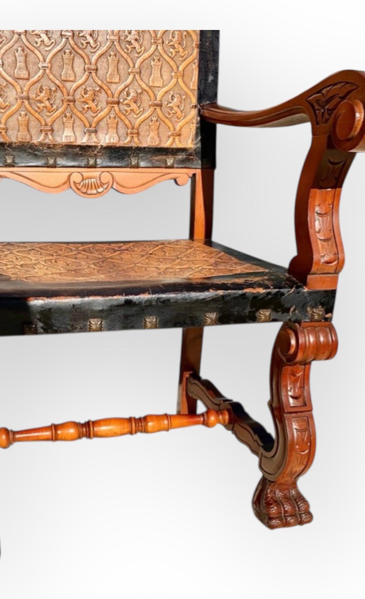 Sculpté à la main Fauteuil ancien en acajou sculpté et cuir gaufré de Castille en vente