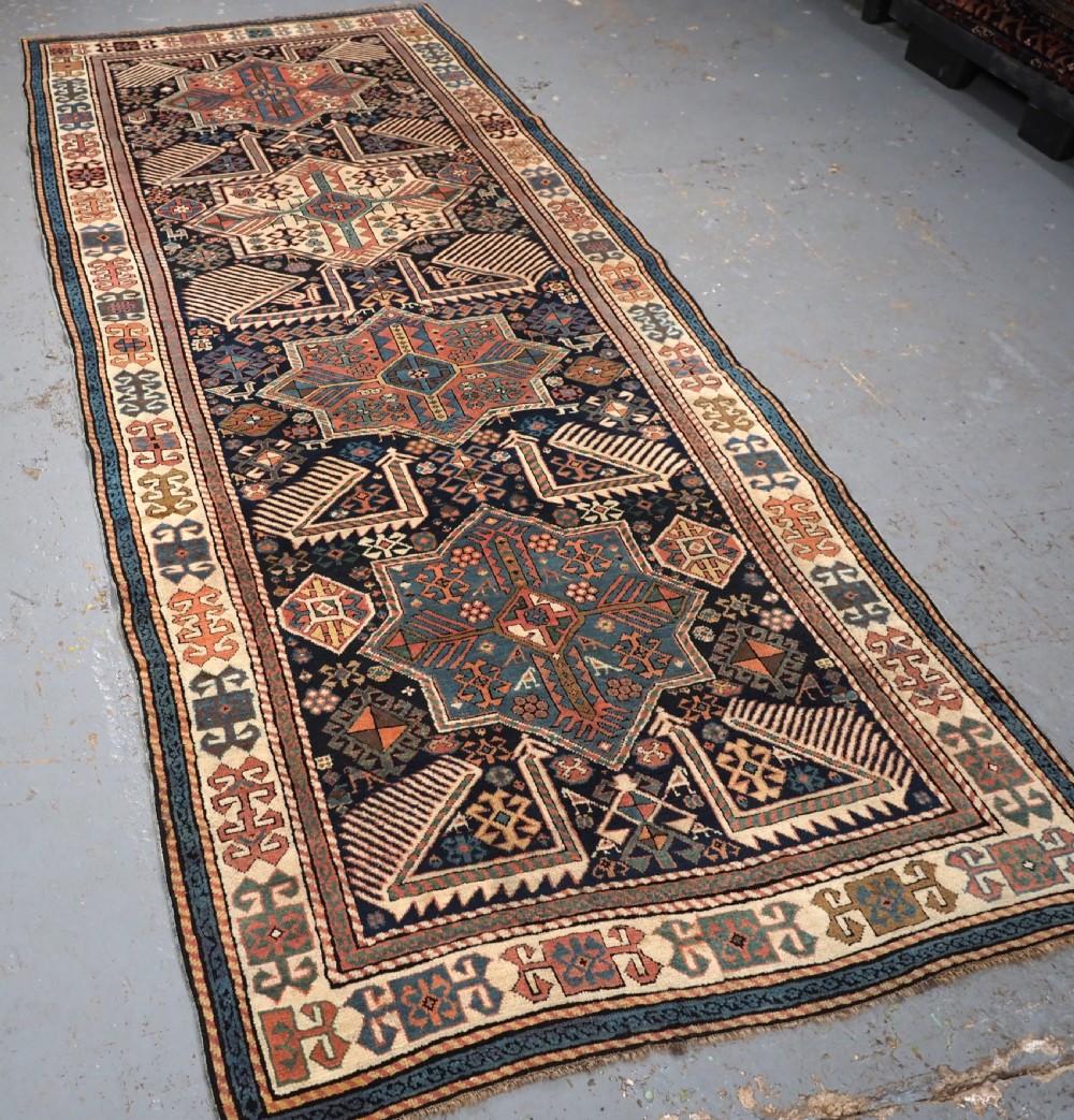 Antique Caucasian Akstafa long rug with four star medallions and birds
Circa 1880

This is a good example of a well known group of long rugs attributed to the town of Akstafa This rug is of classic design with four 'star' medallions on a midnight