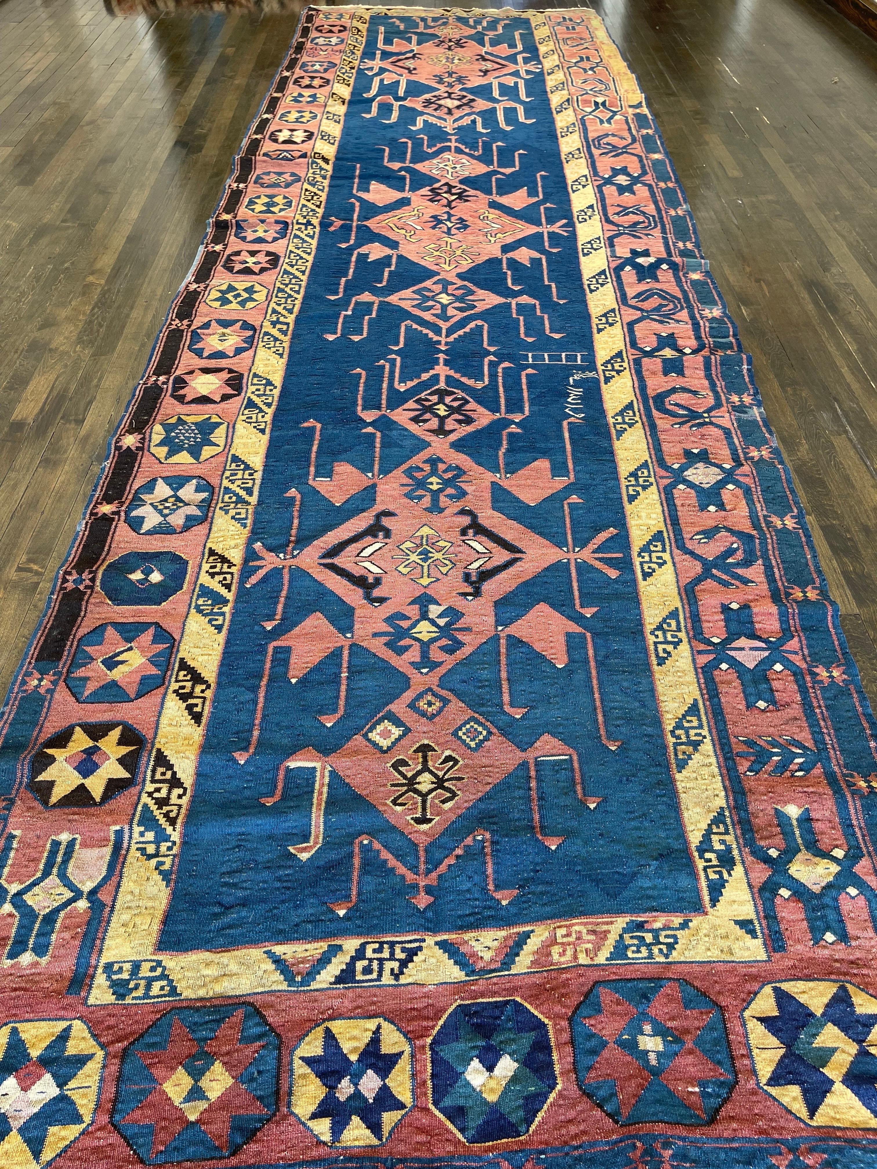 An extraordinary and rare antique Caucasian Avar flat-weave kilim with striking indigo blue field featuring a bold design with intricacy of drawing. The theme of the design is the story of dragon and phoenix combat that is rendered in a primitive
