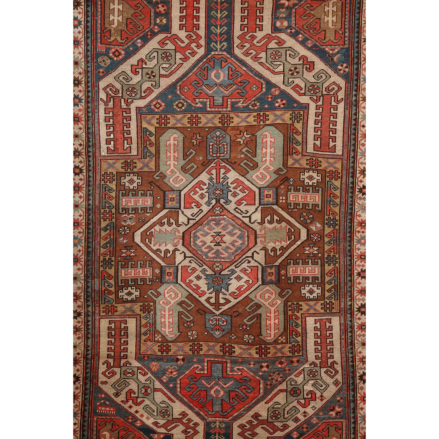 This antique Caucasian carpet in pure handspun wool and vegetable dyes circa 1880 features a multi-layered central medallion with multiple borders and an overall geometric design and field. Its striking composition is well proportioned and further