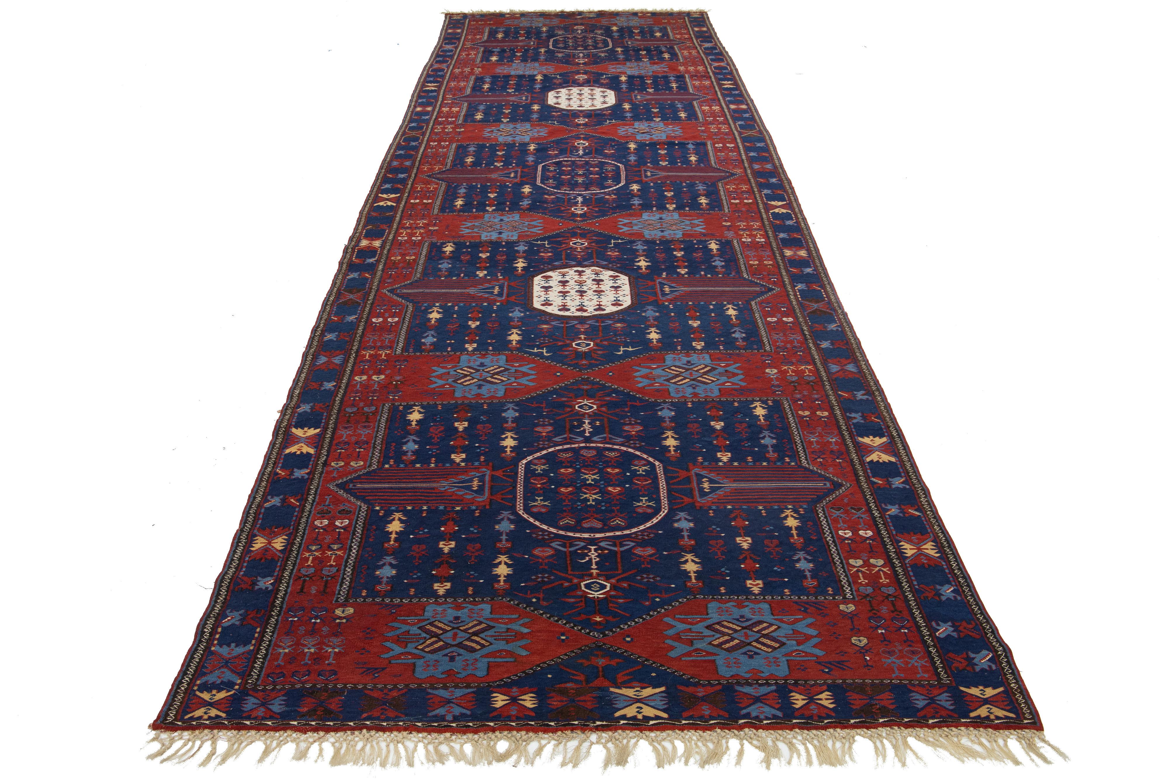 Beautiful antique Caucasian Dagestan hand-knotted wool rug with a navy blue and red field. This piece has a designed frame and an all-over gorgeous tribal design with multicolor accents.

This rug measures 5'7'' x 18'2''.
