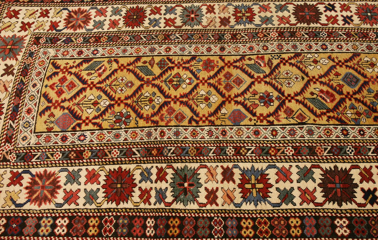 This is a Dagestan runner woven in the northern Caucasus during the end of the 19th century. The field is decorated with shrubs interlock in a lattice design and the border makes use of an abstract crab motif. This runner has highly saturated all