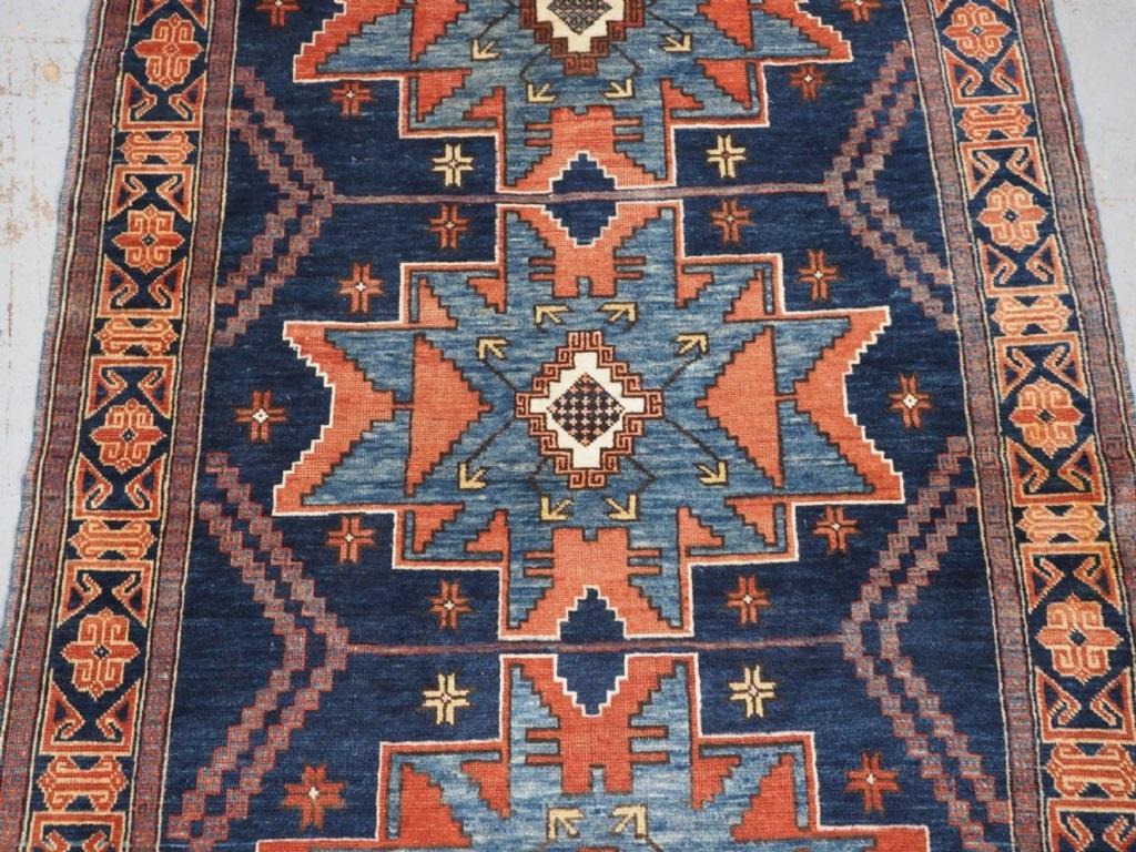 Ancien tapis caucasien Derbent à motifs d'étoiles de Lesghi
Circa 1900

La ville de Derbent est située sur la côte de la mer Caspienne dans le nord-est du Caucase et a une longue tradition de tissage. Ce petit tapis est un bon exemple avec trois