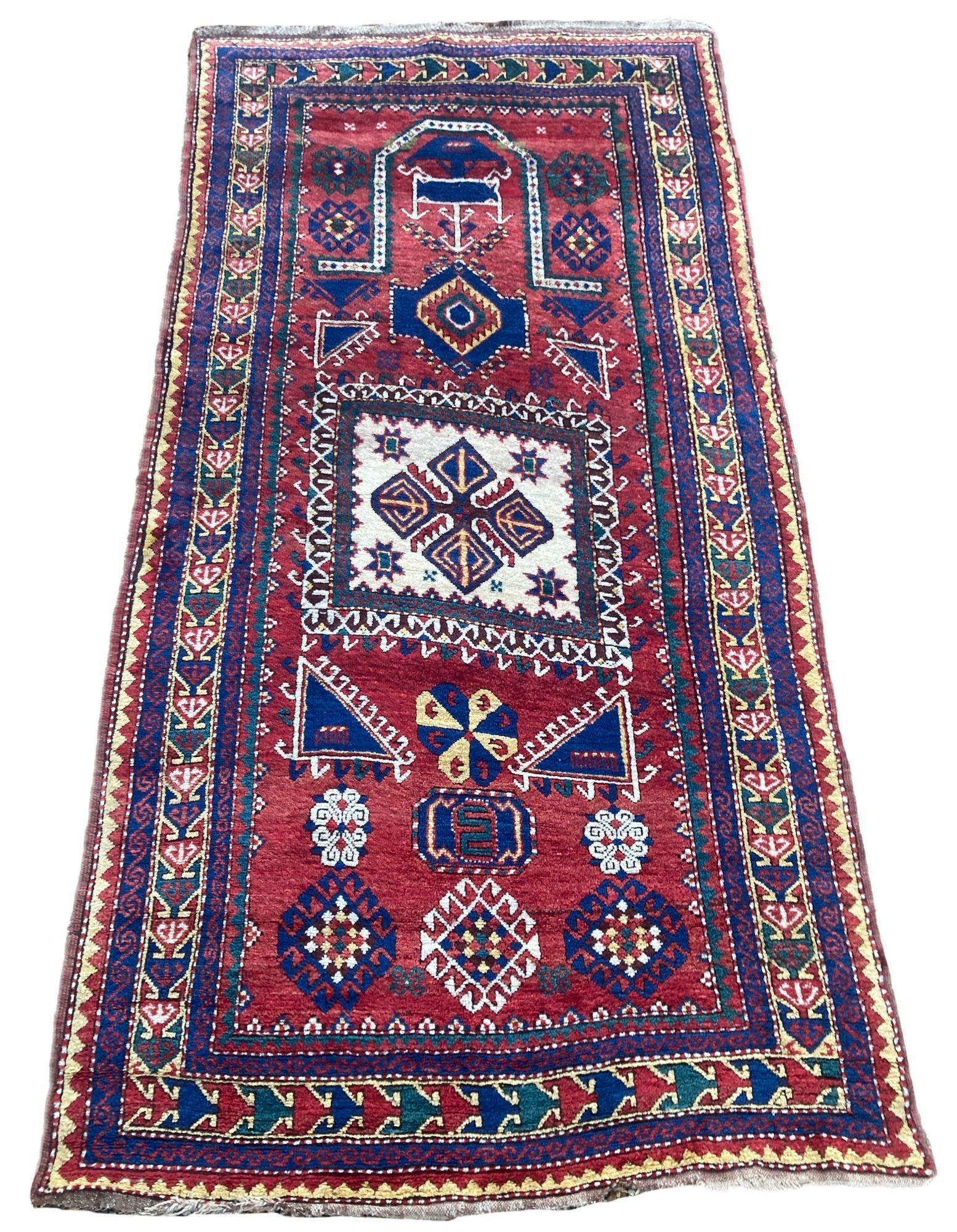 An outstanding antique Fachralo Kazak rug woven in the Caucasus mountains of modern day Georgia circa 1880. The rug features a floating Mihrab or prayer design on a fabulous terracotta red field and saffron border. Full chunky pile, lovely wool