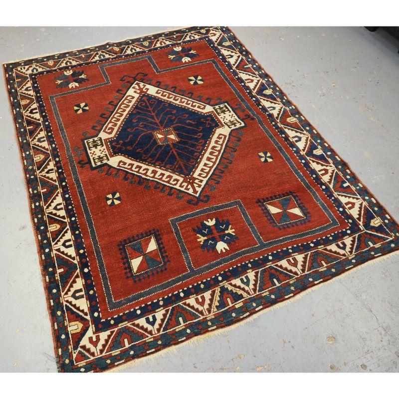Antique Caucasian Fachralo Kazak prayer rug with large single medallion design.

A beautifully drawn rug with an elegant simplicity, the large central latch hook medallion is on a rich red / brown field containing simple box designs and floral