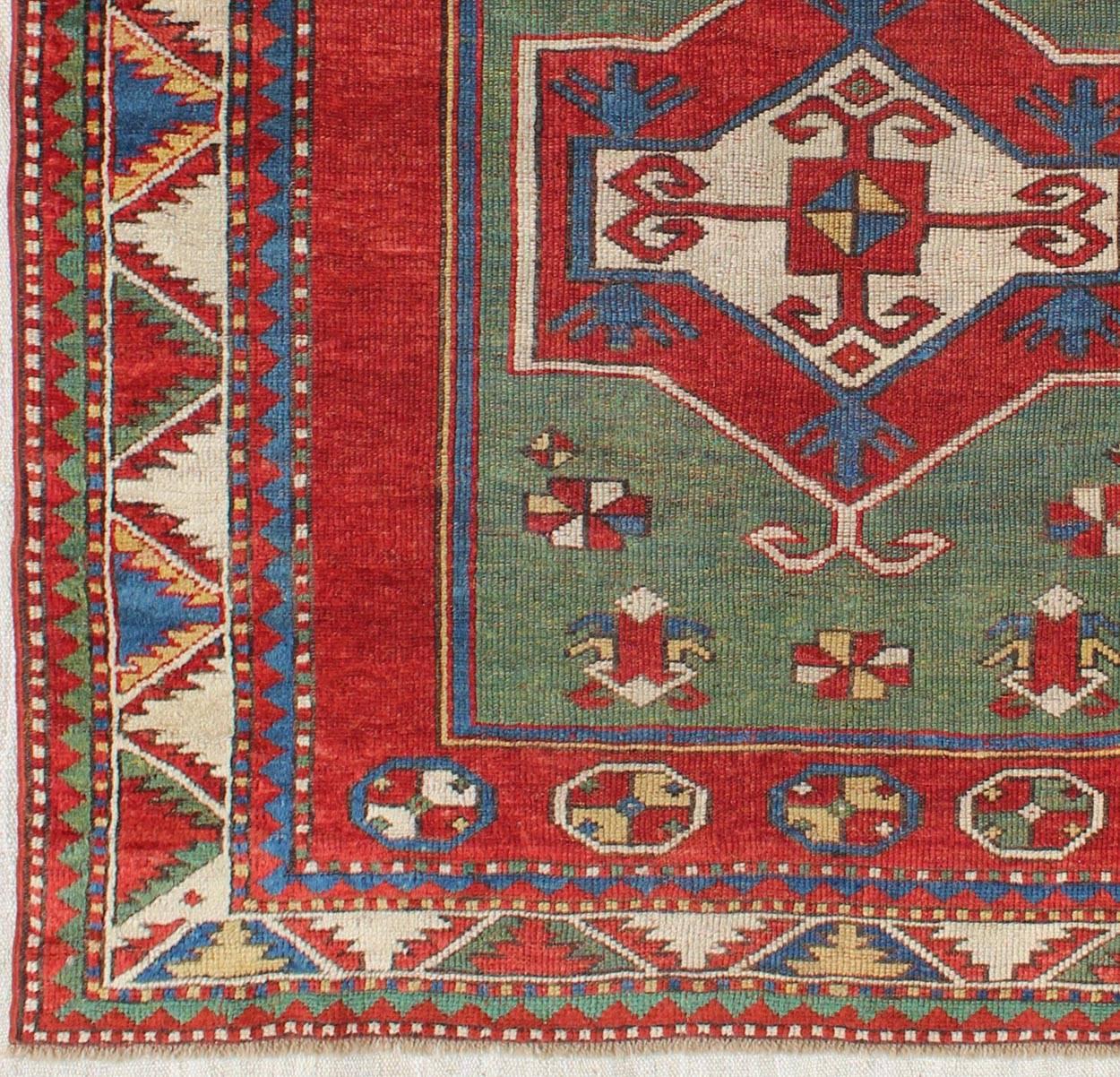 Green Fachralo Kazak, antique Caucasian Kazak rug with Tribal Design in red, blue, green, and ivory, rug 16-0605, country of origin / type: Iran / Caucasian Kazak, circa 1880.

Kazak rugs are among the most desirable Caucasian rugs. The vibrant