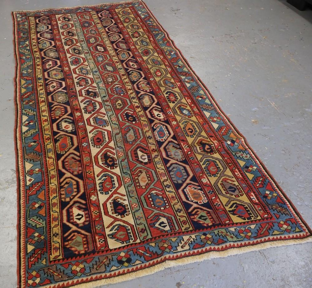 Ancien tapis long caucasien Gendje Kazak à rayures et boteh
Circa 1880

Un bon exemple de tapis long Gendje, des rayures multicolores remplies de boteh et d'une vigne angulaire Les couleurs douces donnent au tapis une sensation de légèreté La
