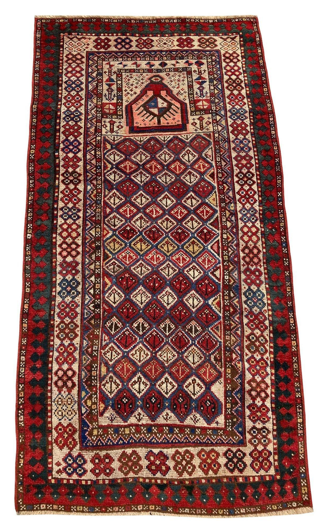 A beautiful little antique Gendje rug, handwoven in The Caucasus mountains of modern day Azerbaijan circa 1890. It features an unusual prayer rug design on a multicoloured lozenge field with an ivory border. Fabulous colours and highly