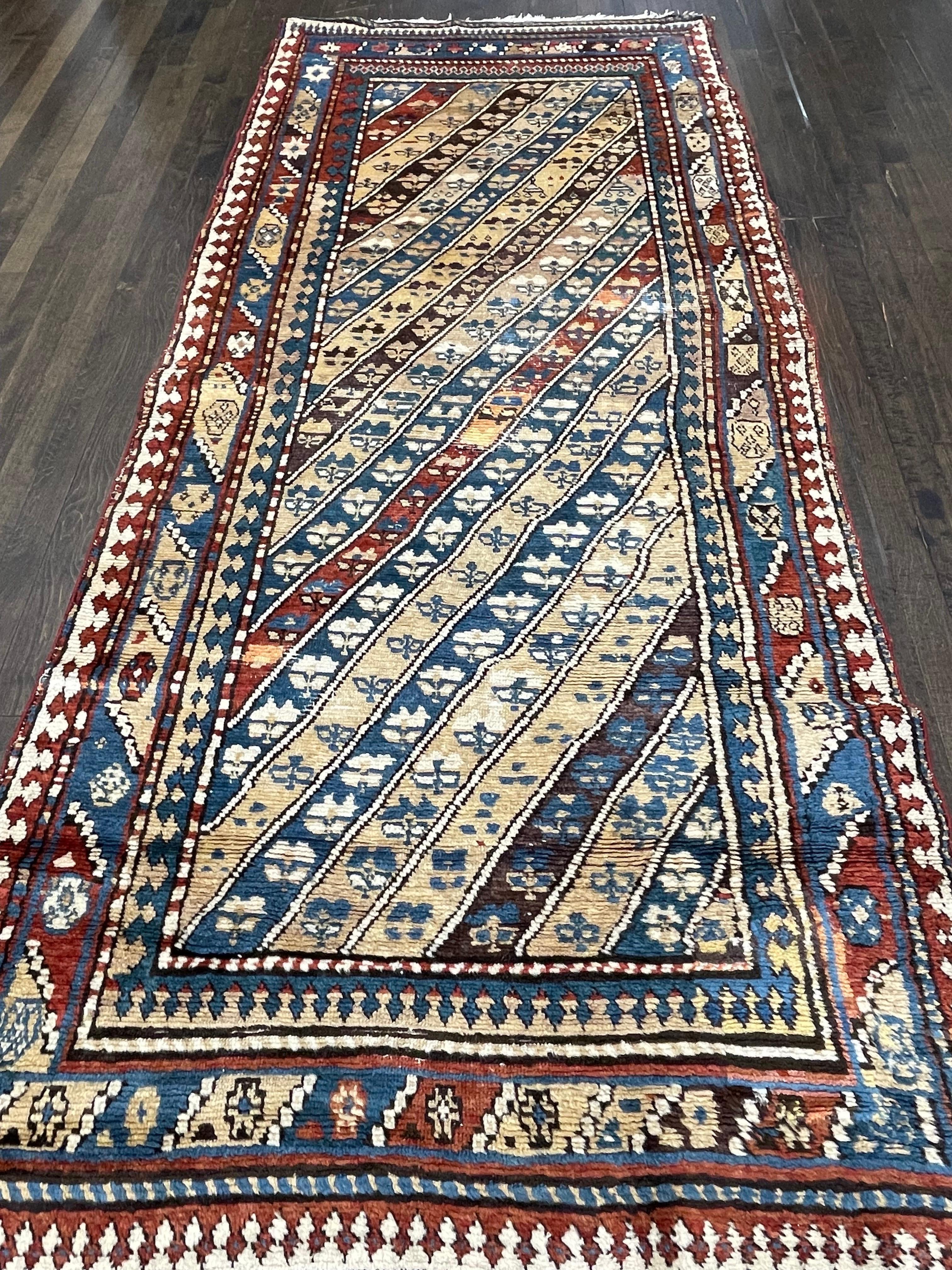 A beautiful runner attributed to Gendje, Azerbaijan, south central caucasus that features the signature design of this group: diagonal, contrasting stripes in vibrant vegetable colors, creating a feeling that they simply run out and under the