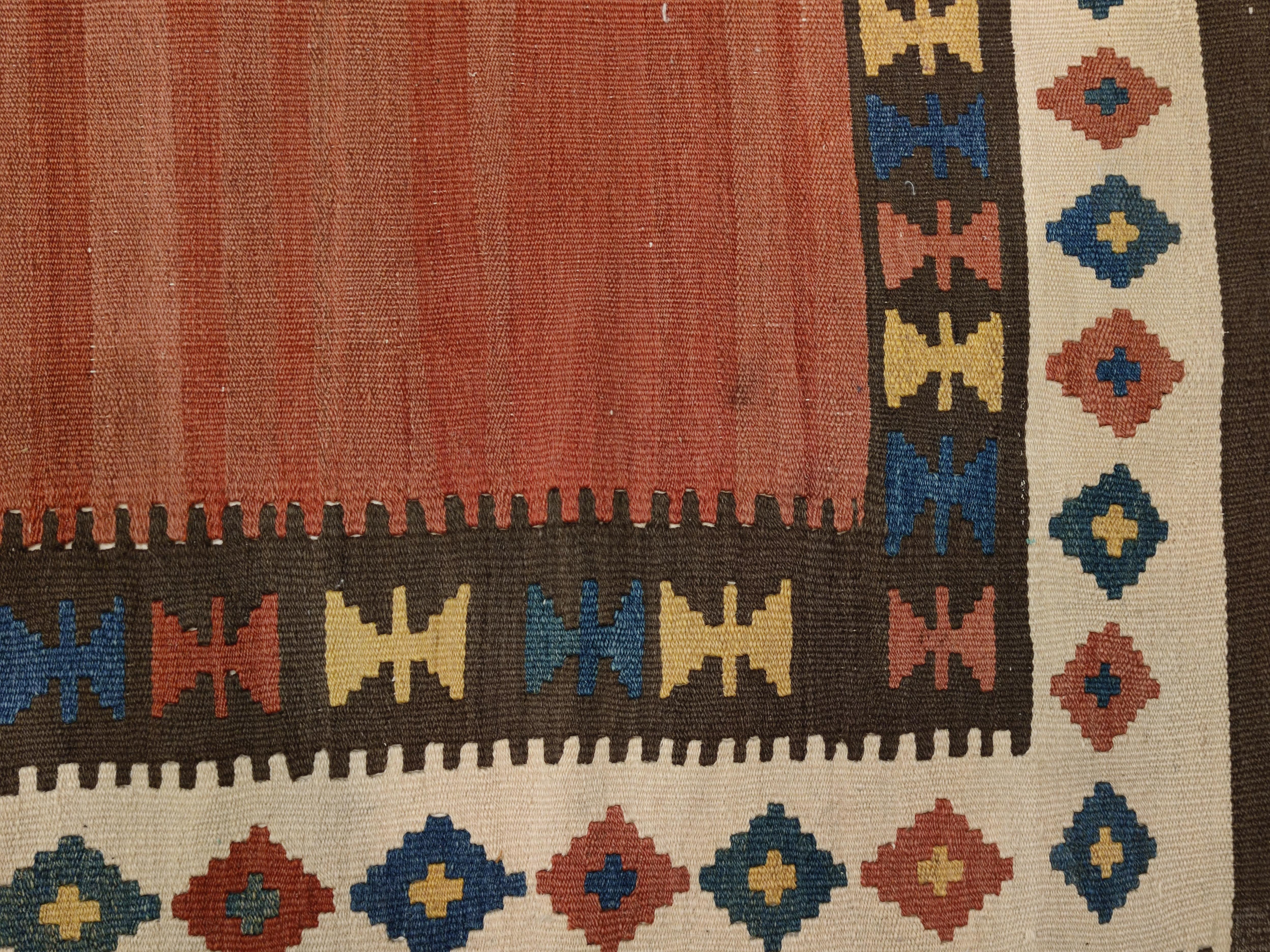 A beautiful antique wool flat-weave from the Shahsavan tribe located in the southern Caucasus. Distinguished by a sparse decoration composed by a totemic motif, which transverses the central axis of the composition with a sequence of diamond-shaped