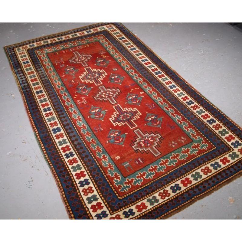 Antiker südkaukasischer Karabagh-Kazak-Teppich mit Memling-Gul-Muster. Der Teppich hat fünf langgestreckte Guls im Memling-Stil auf weichem krapprotem Grund, im Feld finden sich verschiedene kaukasische Musterelemente sowie eine Reihe von Tieren und
