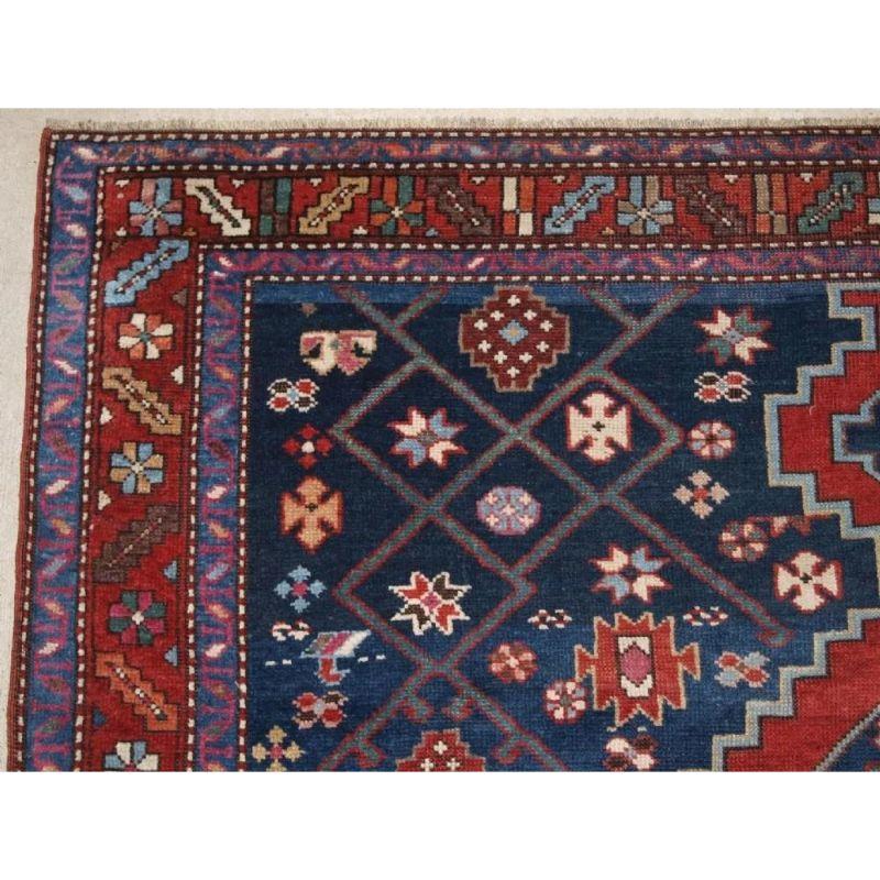 Antique South Caucasian Karabagh kelleh or long rug of large size. The rug has a lattice design on a dark indigo blue ground. There are good reds and greens throughout the rug and the border is very pleasing and on a madder red ground.

The rug is