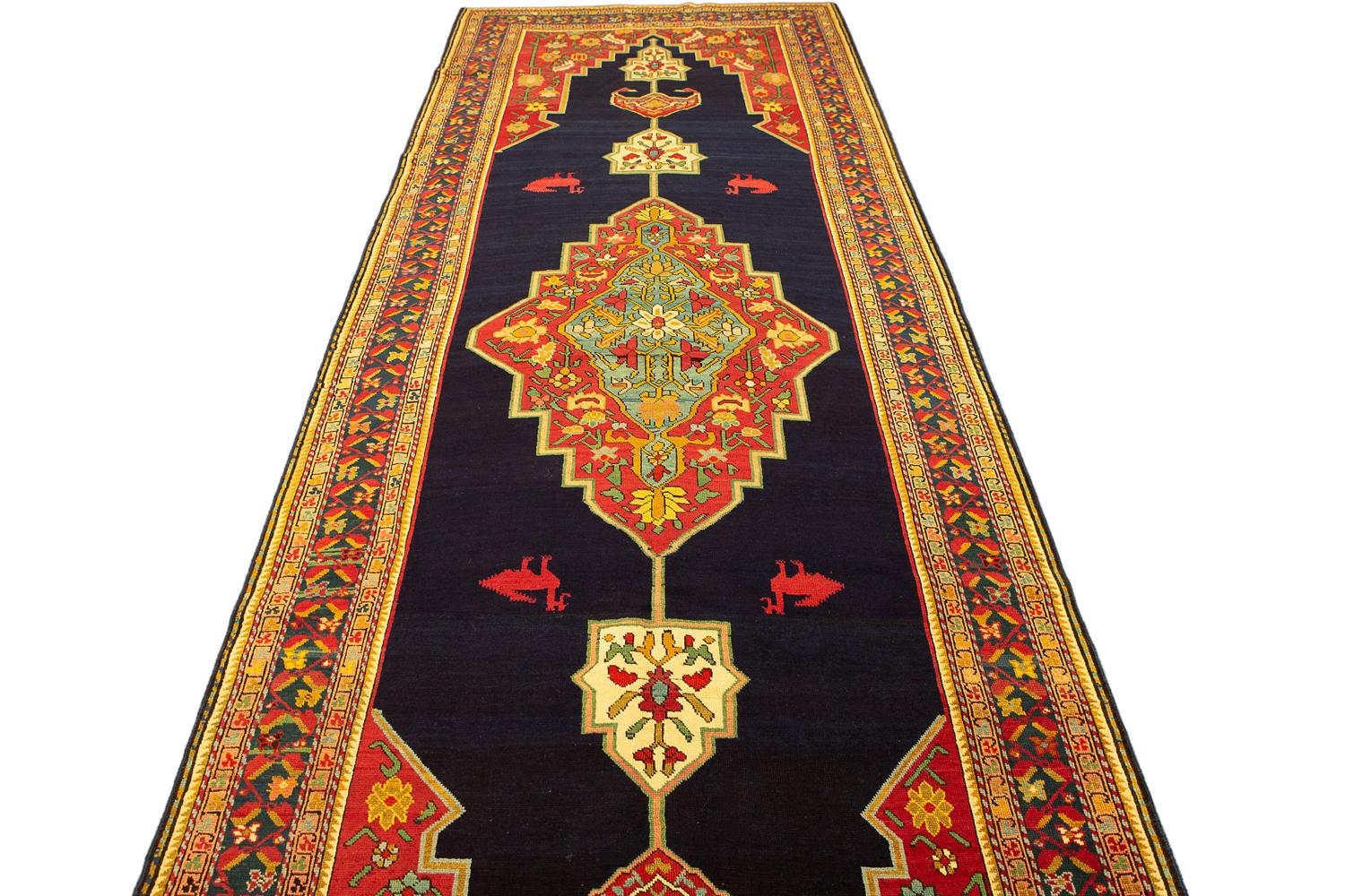 Se trata de una alfombra antigua de Karabaj tejida en el reinado del Cáucaso meridional durante el siglo XIX y mide 405 x 141 cm. El diseño de esta pieza se realiza utilizando un gran medallón central colocado sobre un fondo de campo abierto azul