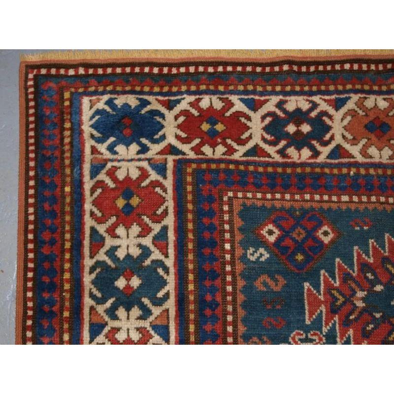 A good example of a Caucasian Karachov Kazak rug with the traditional linked medallion design, on a scare green ground. The rug has four linked medallions on a sea green field, the colour combinations make this a visually striking rug. Note the many