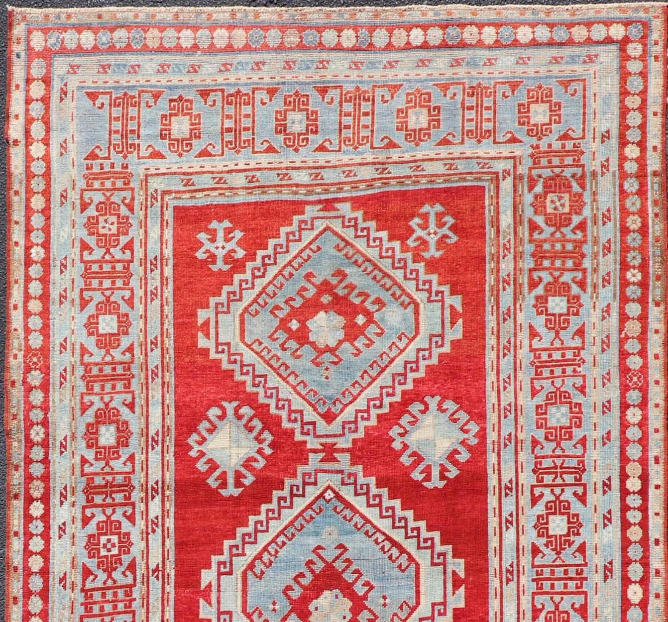 Tribal geometric medallion design Kazak antique rug, antique Caucasian from Caucasus Region with a beautiful red background in multi-colors, 

Measures: 5'0 x 11'0.
 
