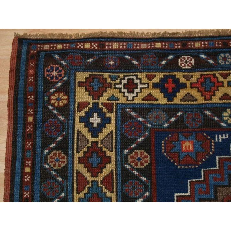 The rug has five latch hook medallions on a indigo blue ground. The field contains a number of large birds and other devices. The borders are an attractive feature with the main border being in a soft yellow. The runner is dated twice at the top