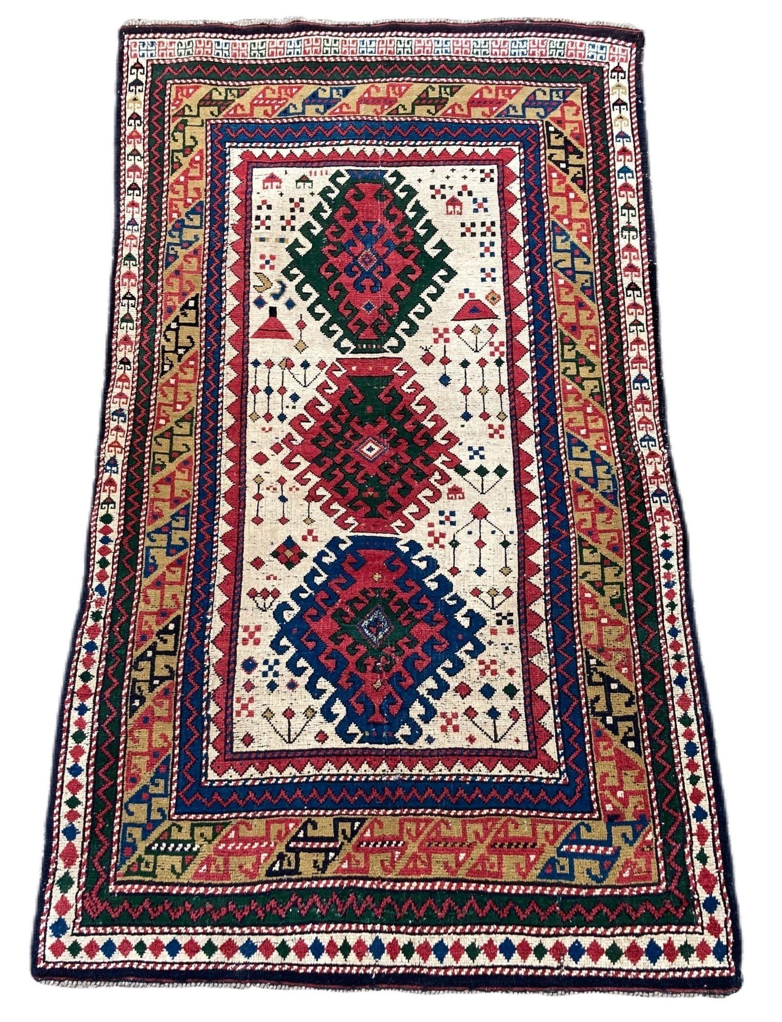 A beautiful little antique Kazak rug, handwoven in the Caucasus mountains of modern day Azerbaijan circa 1920. It features a 3 medallion geometrical design on an ivory field of stylised flowers. Fabulous colours and a great little rug.
Size: 1.82m x