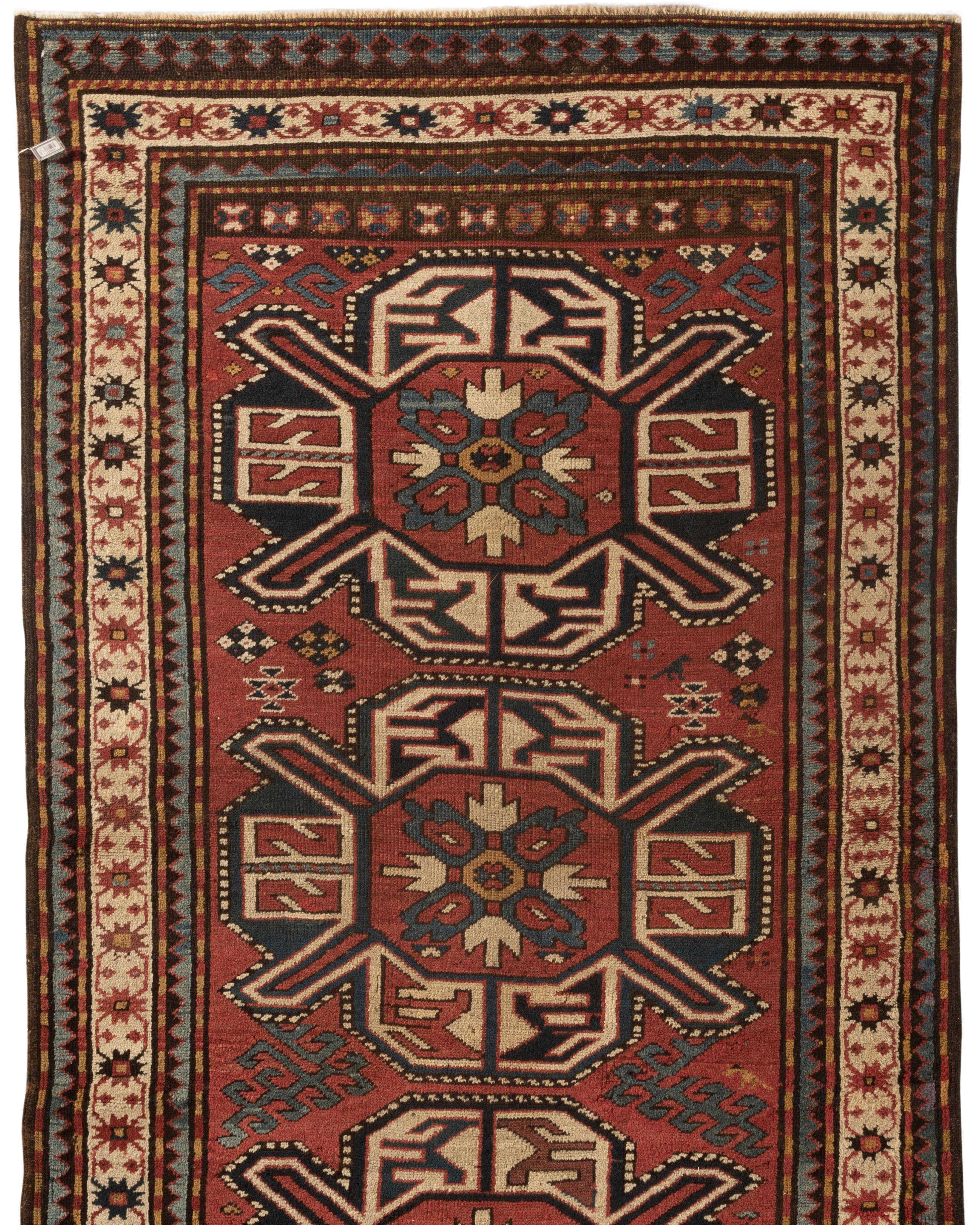 Antique Caucasian Kazak rug, circa 1880. A south west Caucasian Kazak handwoven rug the three central diamond shapes with floral and ethnic designs enclosed in an ivory border full of floriated designs and then enclosed within guard borders in soft