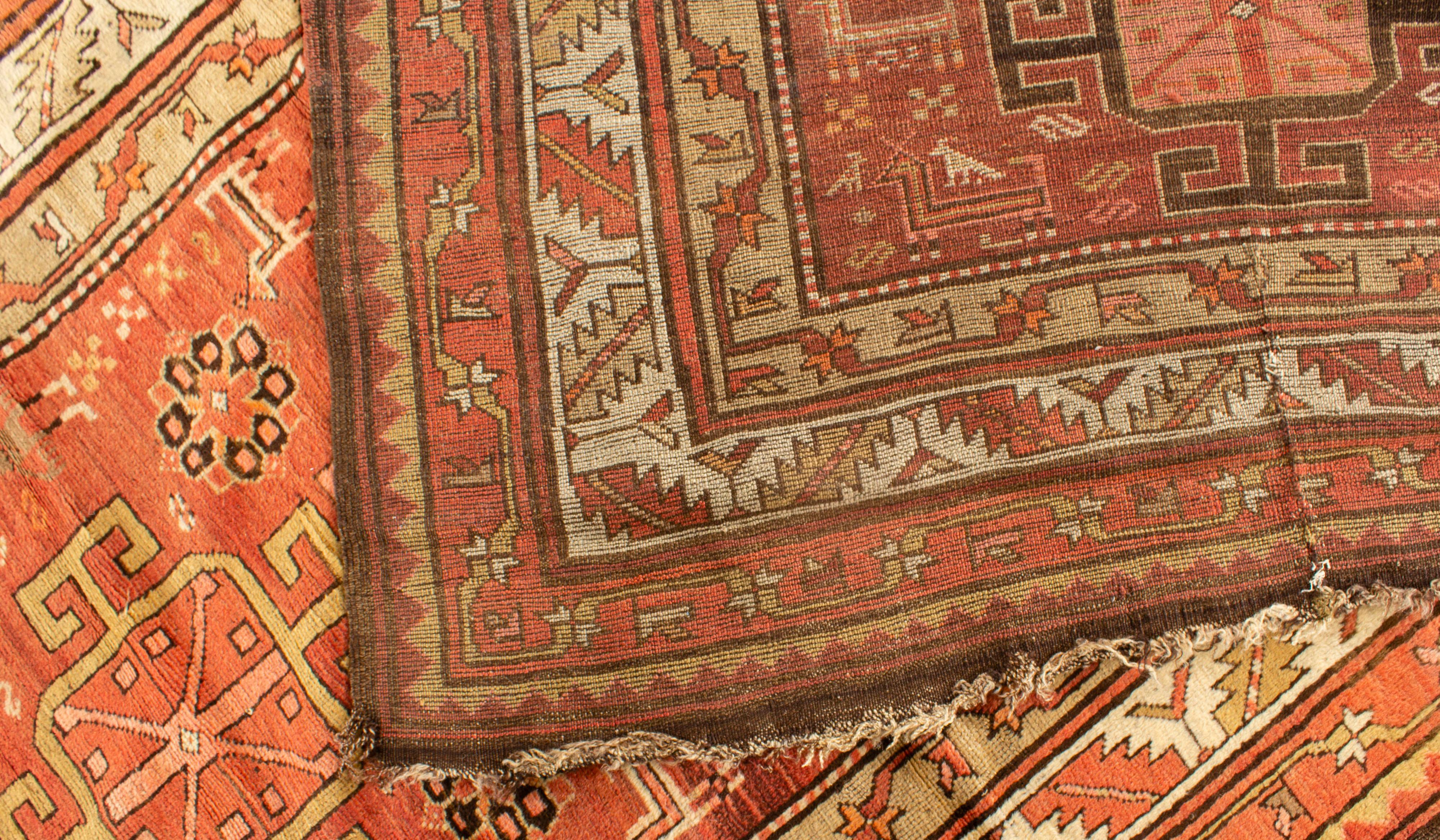 Tapis Kazak du sud-ouest du Caucase tissé à la main, vers 1890. Une succession de bordures de couleurs et de motifs différents entoure le centre de ce tapis, qui comporte cinq médaillons ainsi que des motifs détaillés et complexes, notamment des
