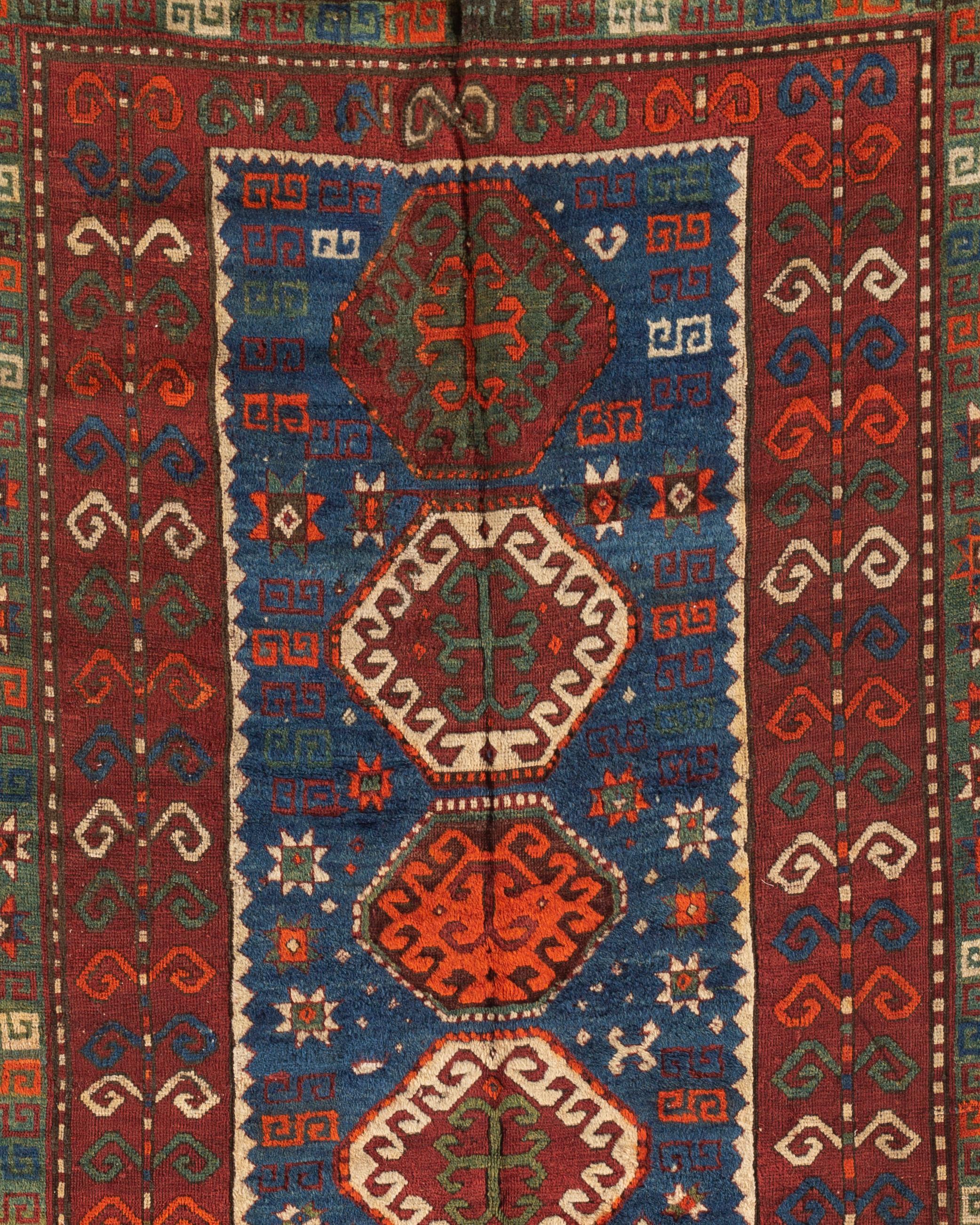 Antiker kaukasischer Kazak-Teppich, um 1900. Ein südwestkaukasischer kasachischer handgewebter Teppich, um 1900. Mit einem zentralen blauen Muster, das fünf Motive in einem roten Feld einschließt, das von mehreren Schutzleisten umgeben ist. Die
