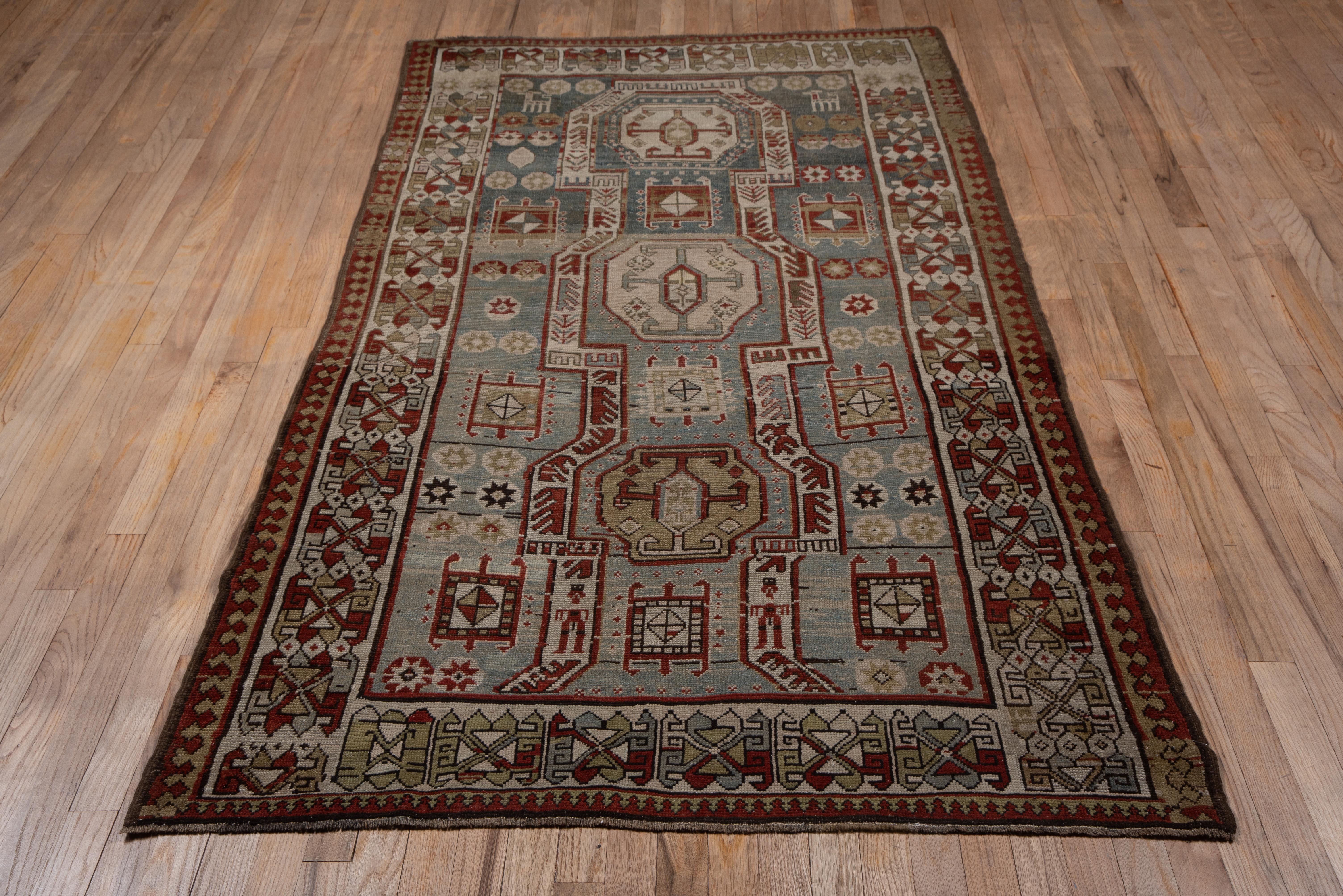 Although coarse like a typical Caucasian Kazak, the design is derived from east Caucasian Shirvan rugs with its elongated head and foot panel enclosing octogons in ivory and straw. The abrashed teal ground is particularly attractive and is adorned