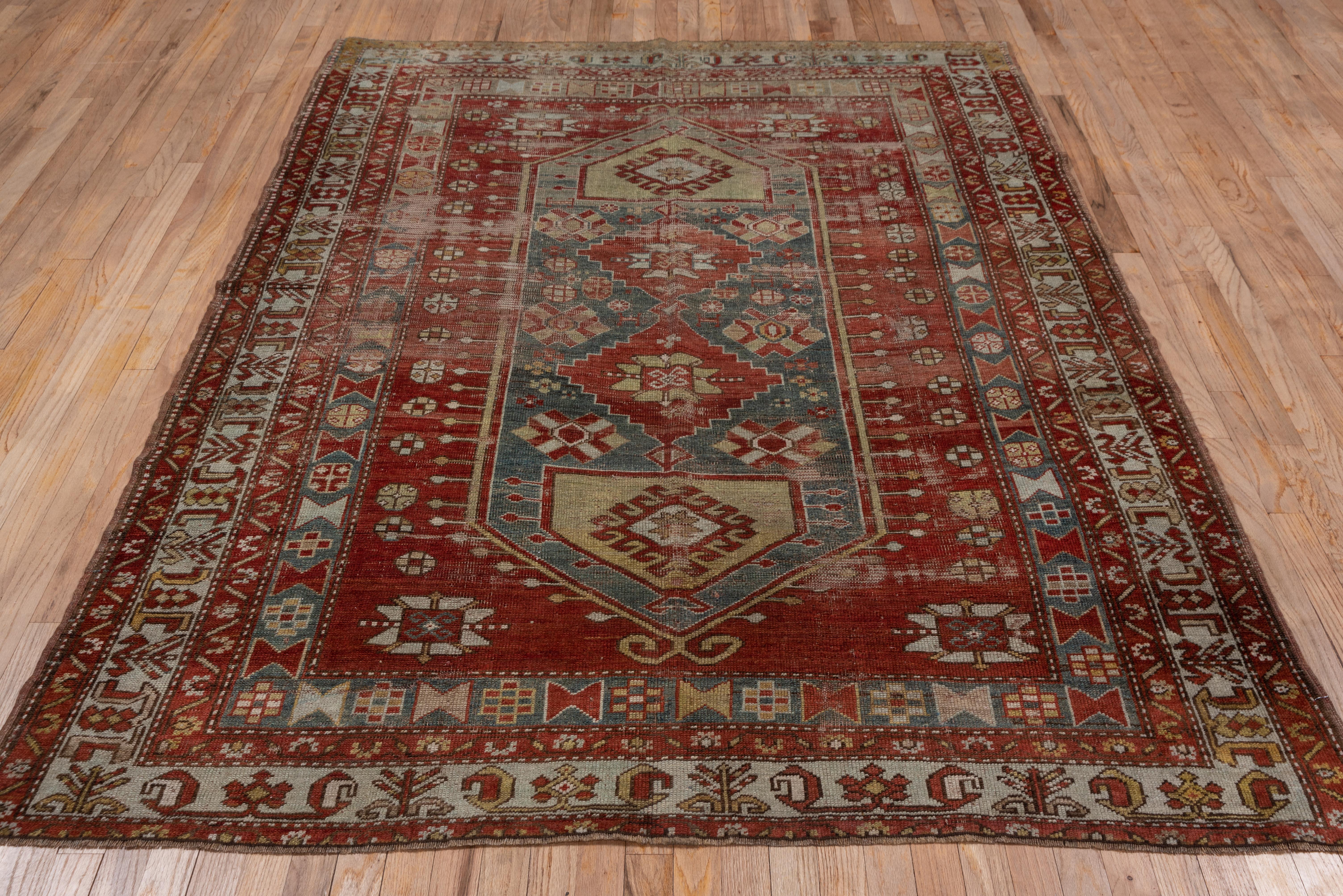 This south Caucasian rug in partially distressed condition features a green extended hexagonal panel with a pole medallion of stepped red diamonds terminating in bold straw pentagons. Beige 