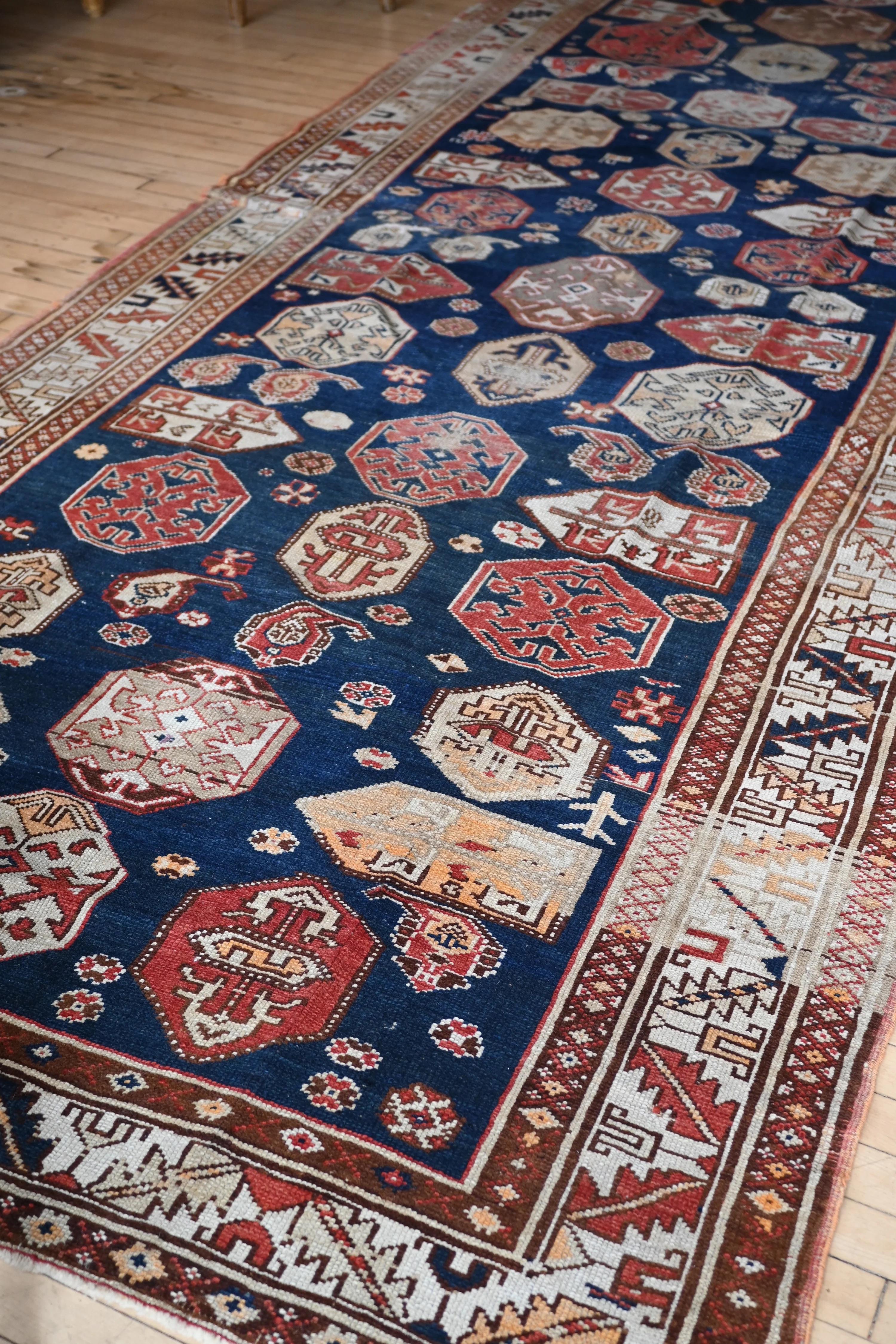 Tapis de galerie du début du siècle avec un champ bleu marine et des médaillons à grande échelle. Un médaillon inhabituel sur toute sa surface. Pile très basse.