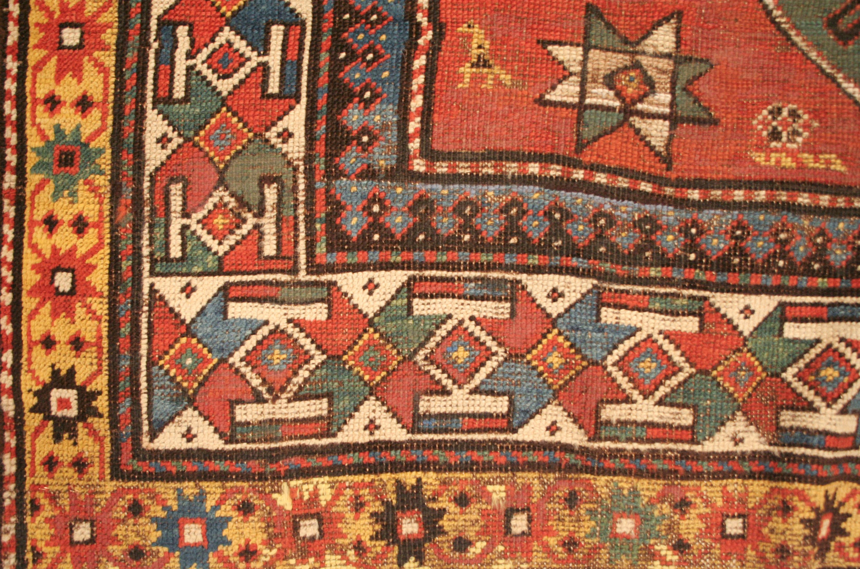 By having its size previously adjusted, this antique Kazak rug displays an unusual two-medallion design. Here two emerald green polygonal devices dominate the terracotta background, which is sparsely embellished by small diamonds, eight-pointed