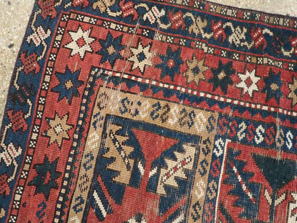 20ième siècle Tapis du Caucase en mauvais état avec un motif tribal en rouille, bleu foncé et crème en vente