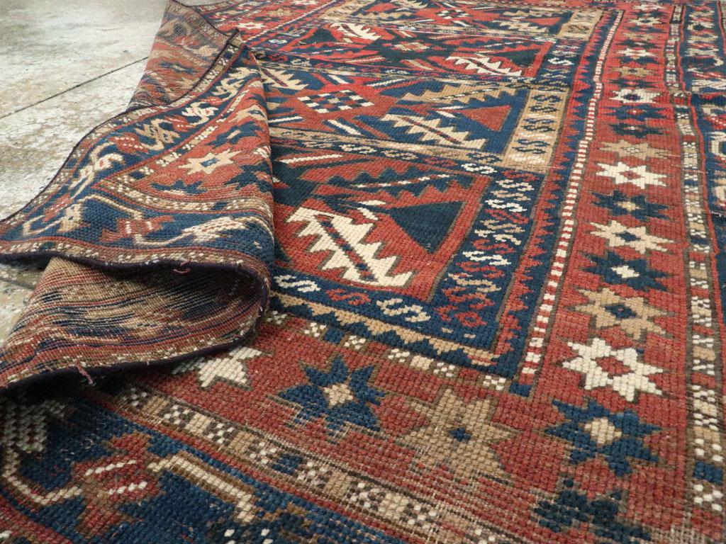 Distressed Caucasian Rug With A Tribal Design In Rust, Dark Blue, And Cream For Sale 2