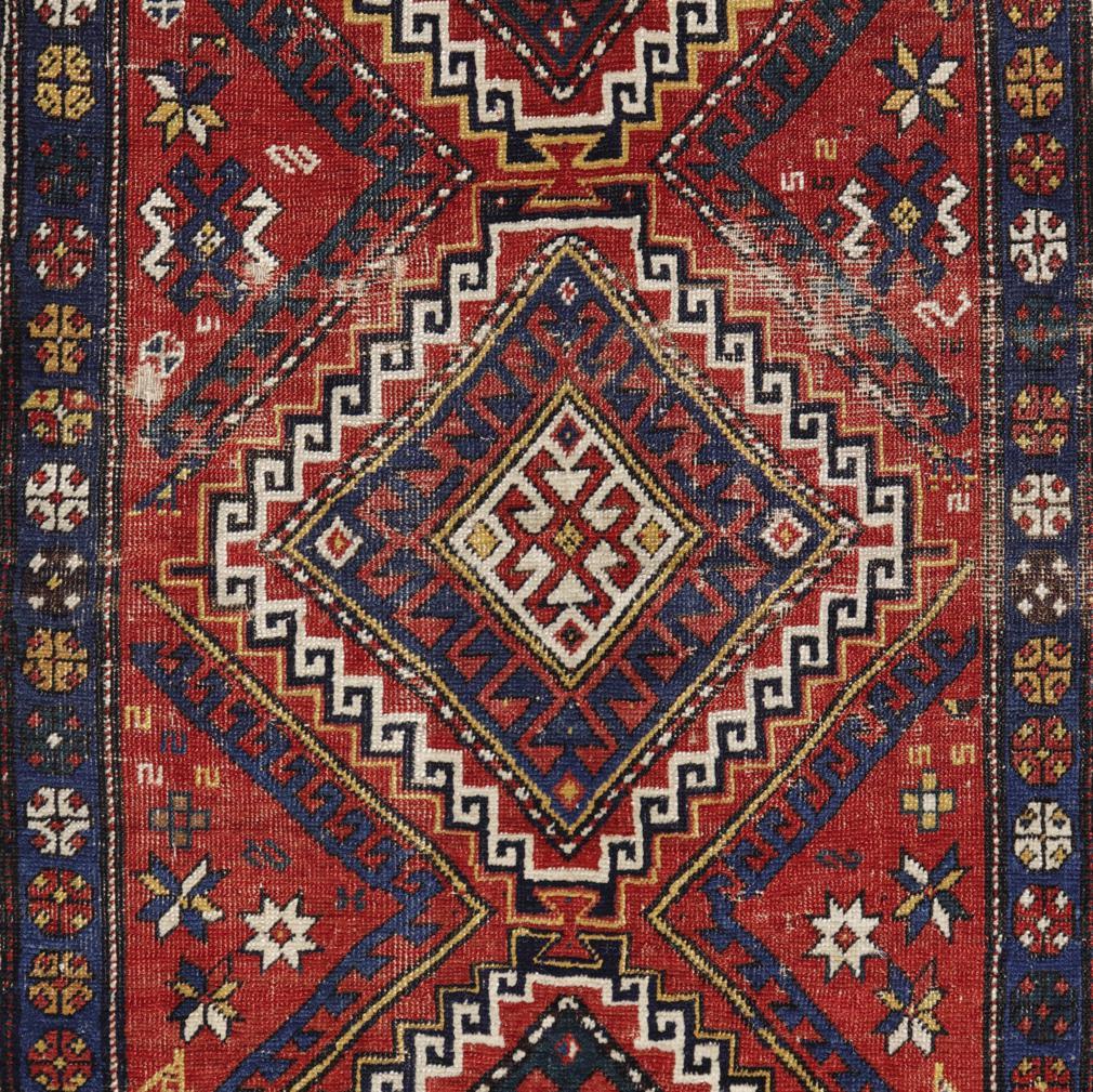 An antique Caucasian Kazak rug, Russian Empire (1721-1917). A fine wool pile in Turkish knot tightly woven on an all wool base. A geometric design consisting of three large Shulavar medallions with the inward pointing arrowheads in blue, green,