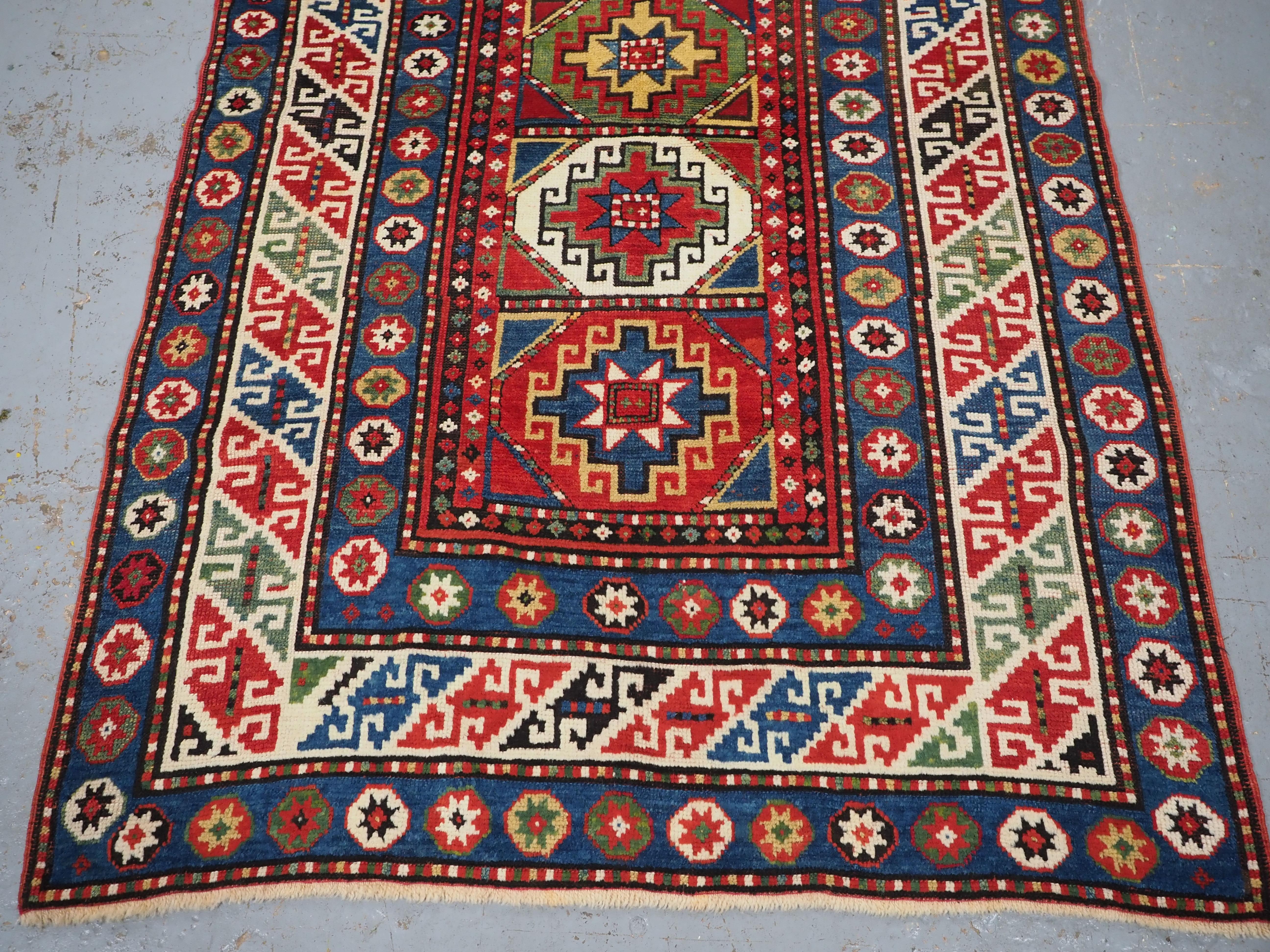 Wool Antique Caucasian Kazak rug with a single column of boxed 'Memlinc guls'. For Sale