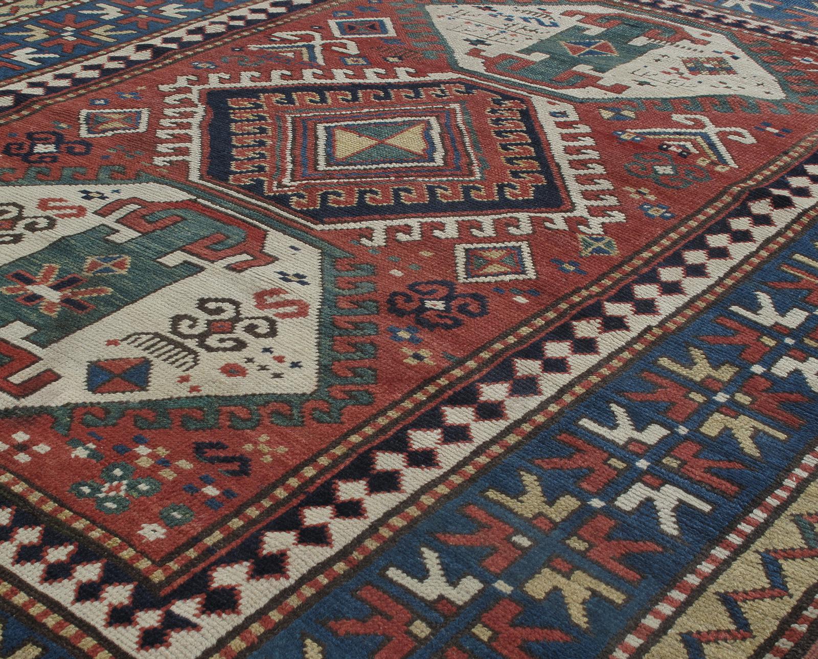 Cet ancien tapis tribal caucasien à motif kazakh provient d'Azerbaïdjan, un pays situé dans la région du Caucase du Sud. Il est fabriqué en 100% laine filée à la main et en teintures naturelles. Ce tapis présente un motif géométrique audacieux et