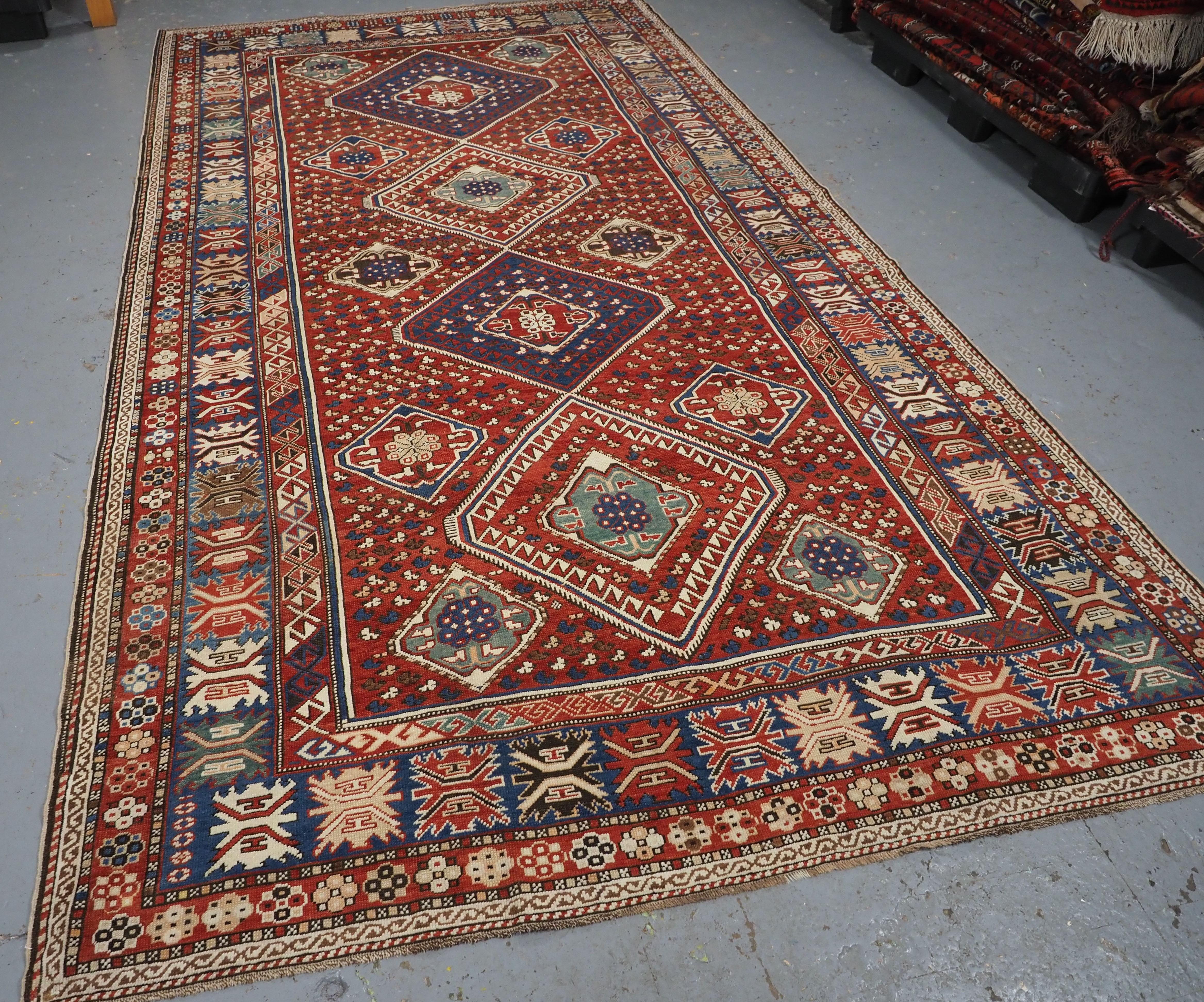 Size: 10ft 11in x 6ft 0in (332 x 184cm).

Antique Caucasian Khila rug from the Baku region of the Eastern Caucasus.

Circa 1890.

This is an outstanding example of this type of rug, with four large diamond medallions on a madder red ground. The