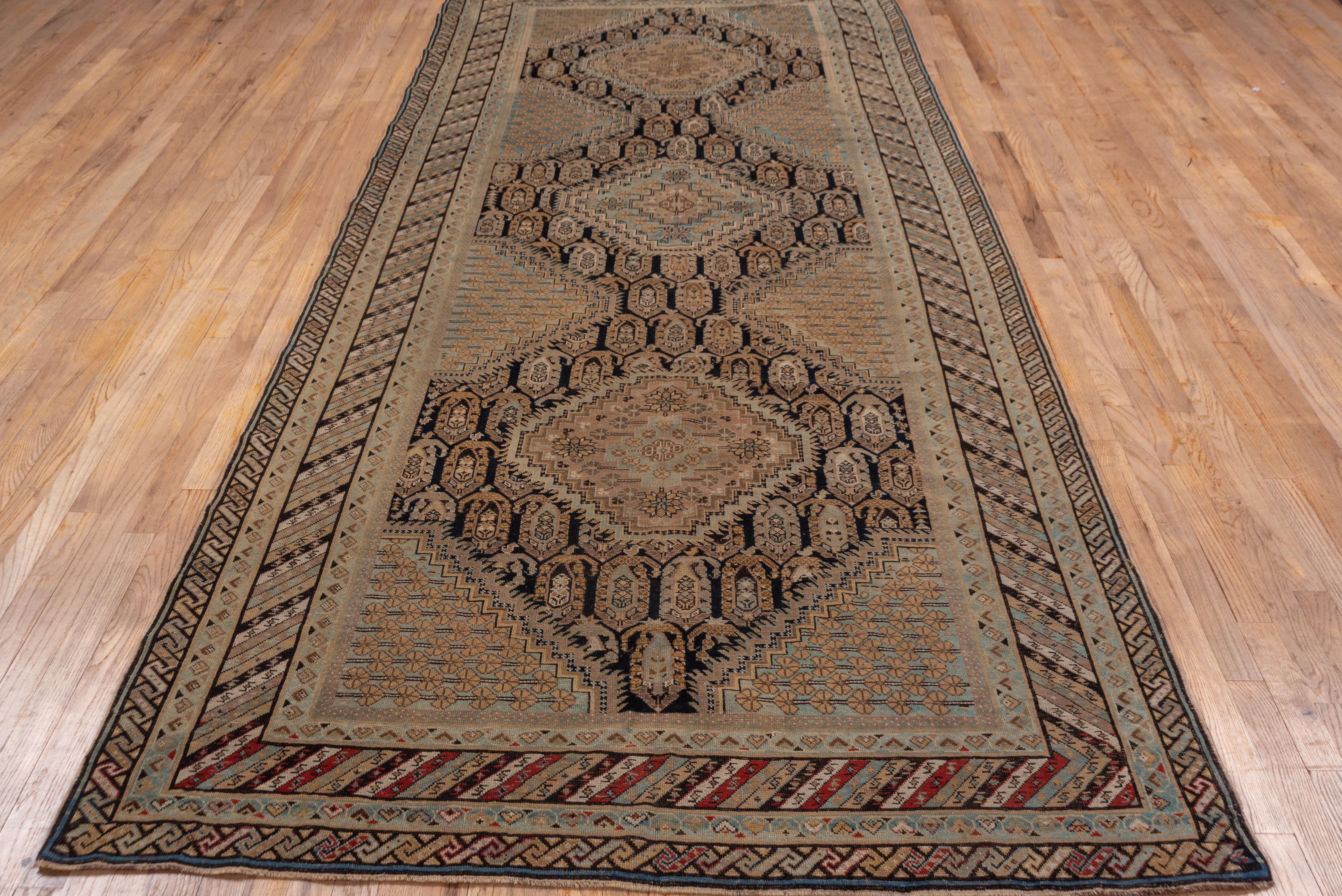 Classic black ground east Caucasian rug with three stepped octagon medallions and matching side and corner motives, with botehs behind and a diagonally striped border.