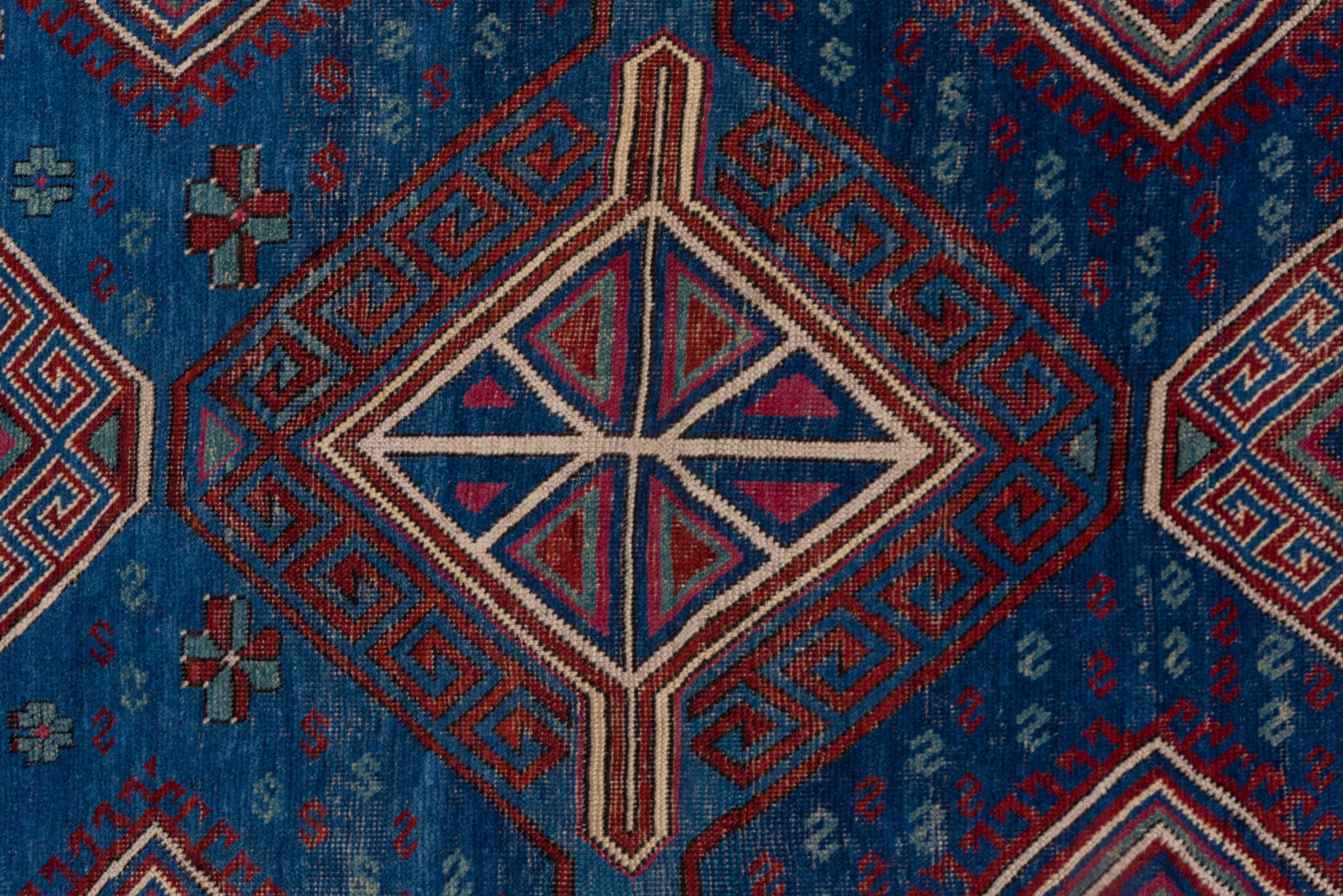 Tribal Antique Caucasian Kuba Area Rug, Dark Blue Field, Red Borders, Pink Accents For Sale