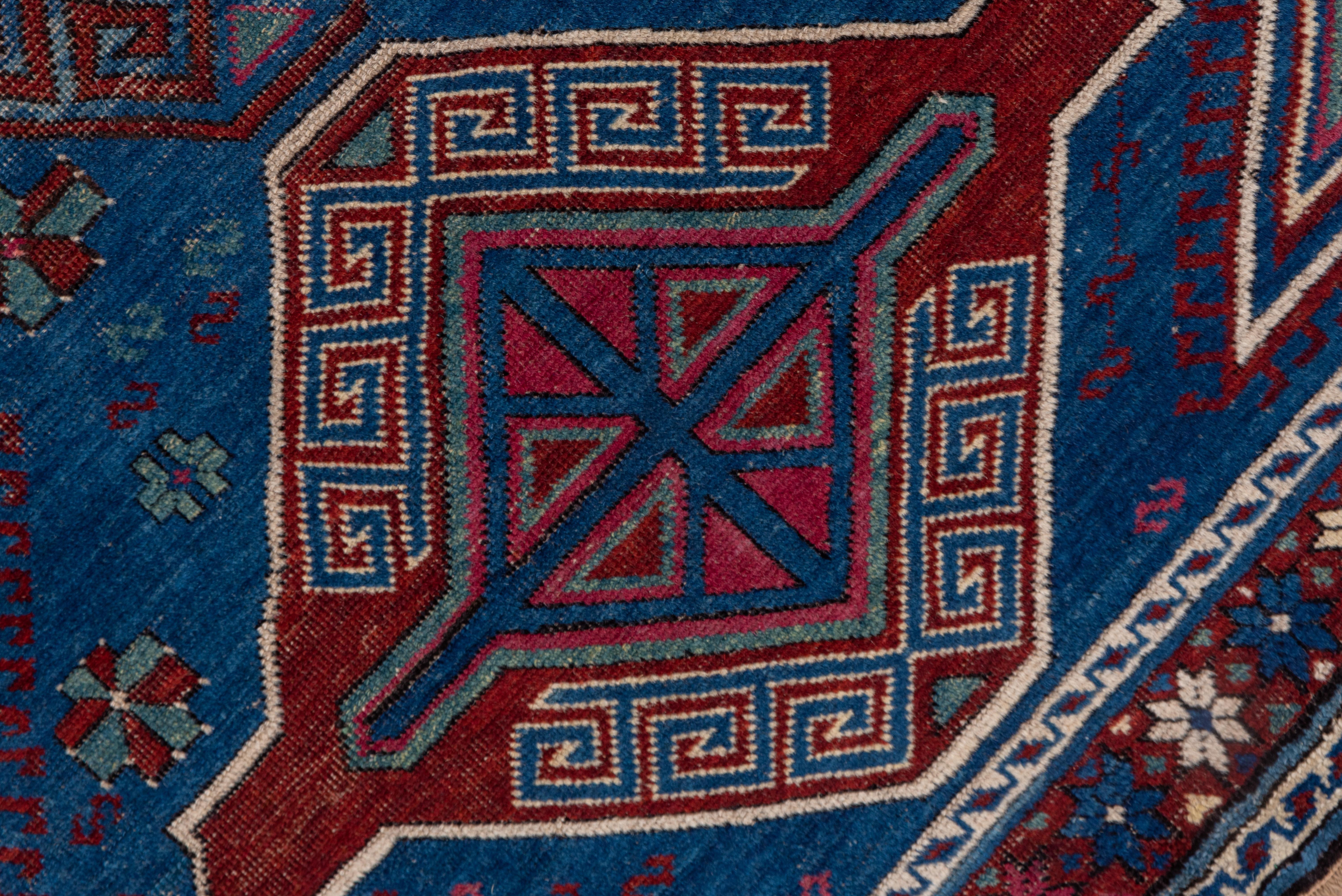 Hand-Knotted Antique Caucasian Kuba Area Rug, Dark Blue Field, Red Borders, Pink Accents For Sale
