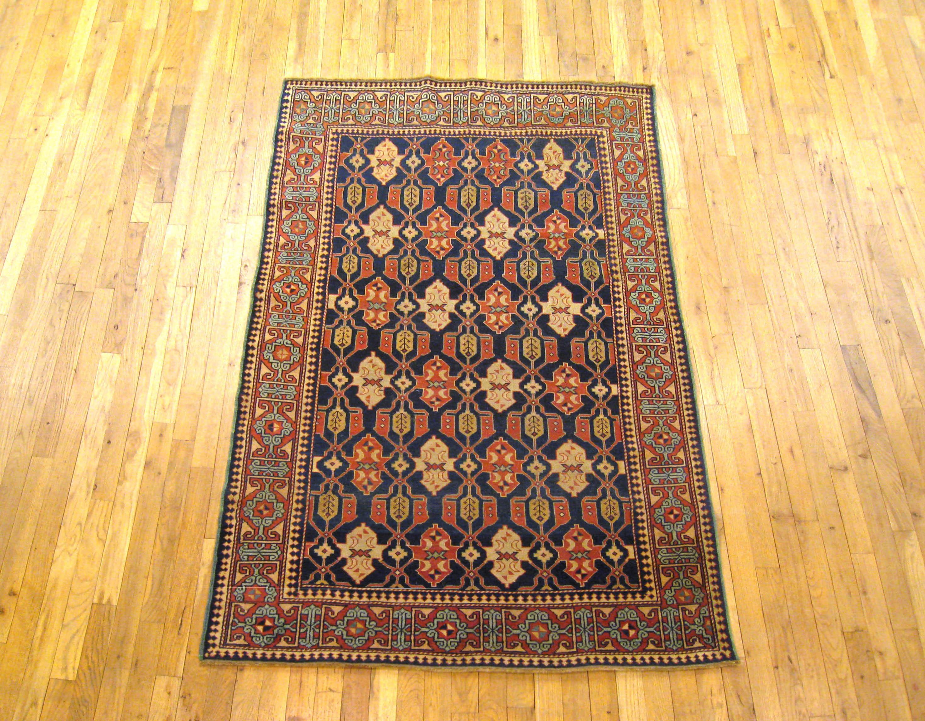 An antique Caucasian Kuba oriental rug, circa 1900, size 6' x 4'. This handsome carpet features a repeating geometric design in the deep blue field and a strong scrolling border of complimentary color and design. This is a good, solid rug, great for