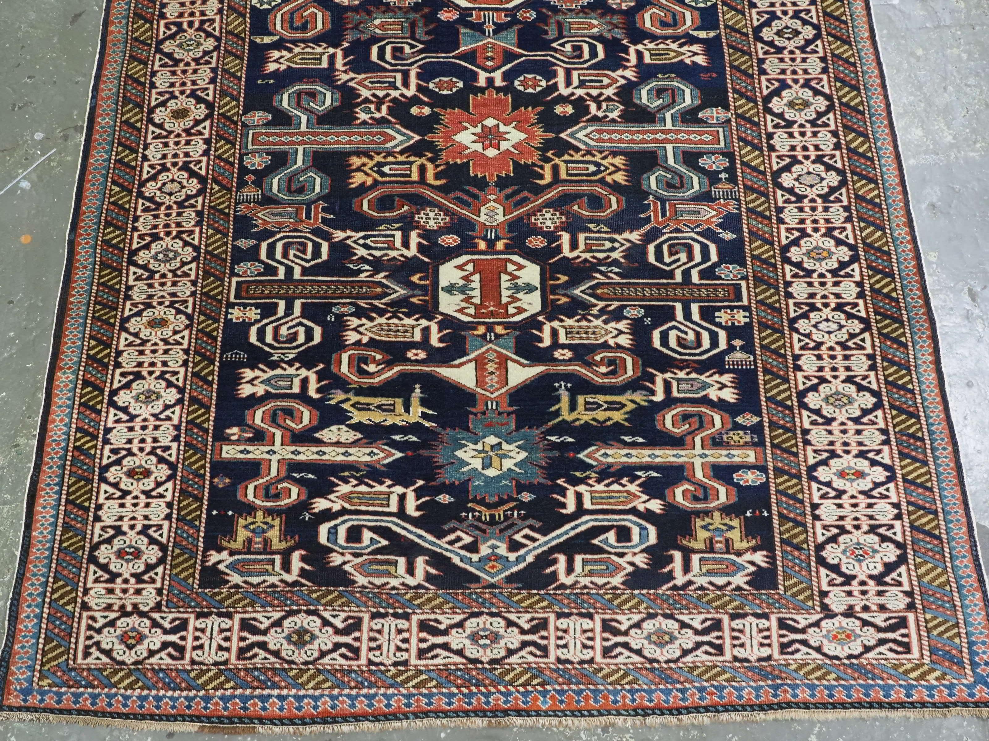 Wool Antique Caucasian Kuba region Perepedil rug with an indigo blue ground. For Sale