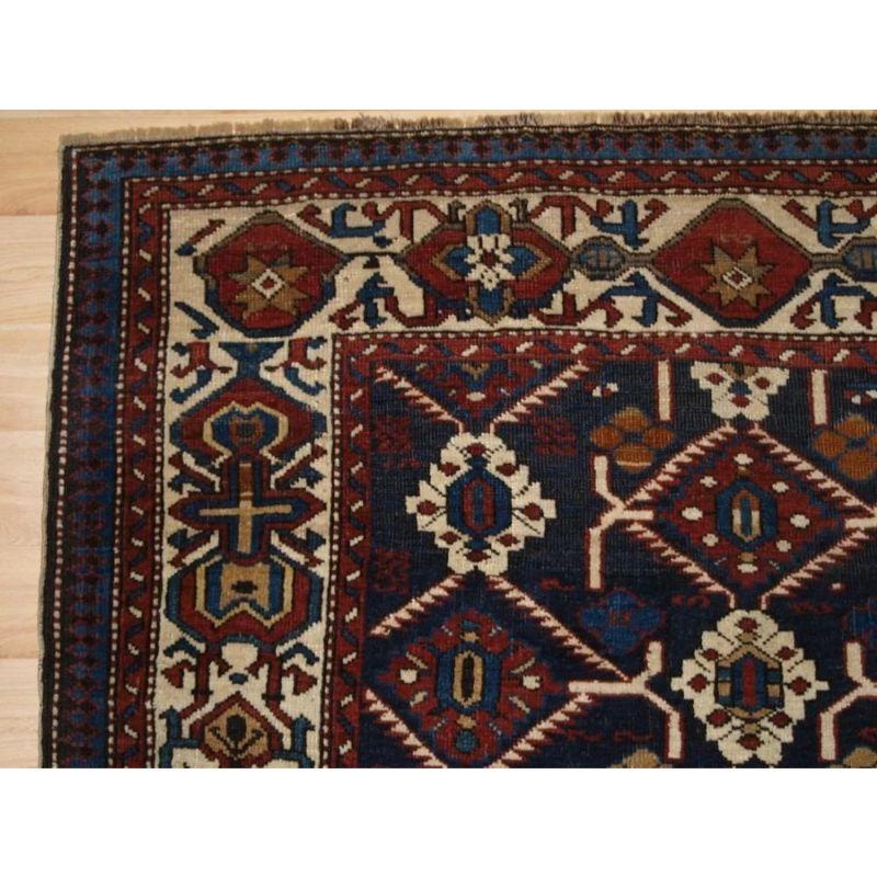 A good Shirvan rug from the Kuba region with an unusual large scale lattice design of stylised floral medallions. This style can be traced back to the large floral carpets found in this region during the 17th and 18th centuries. The rug is framed by