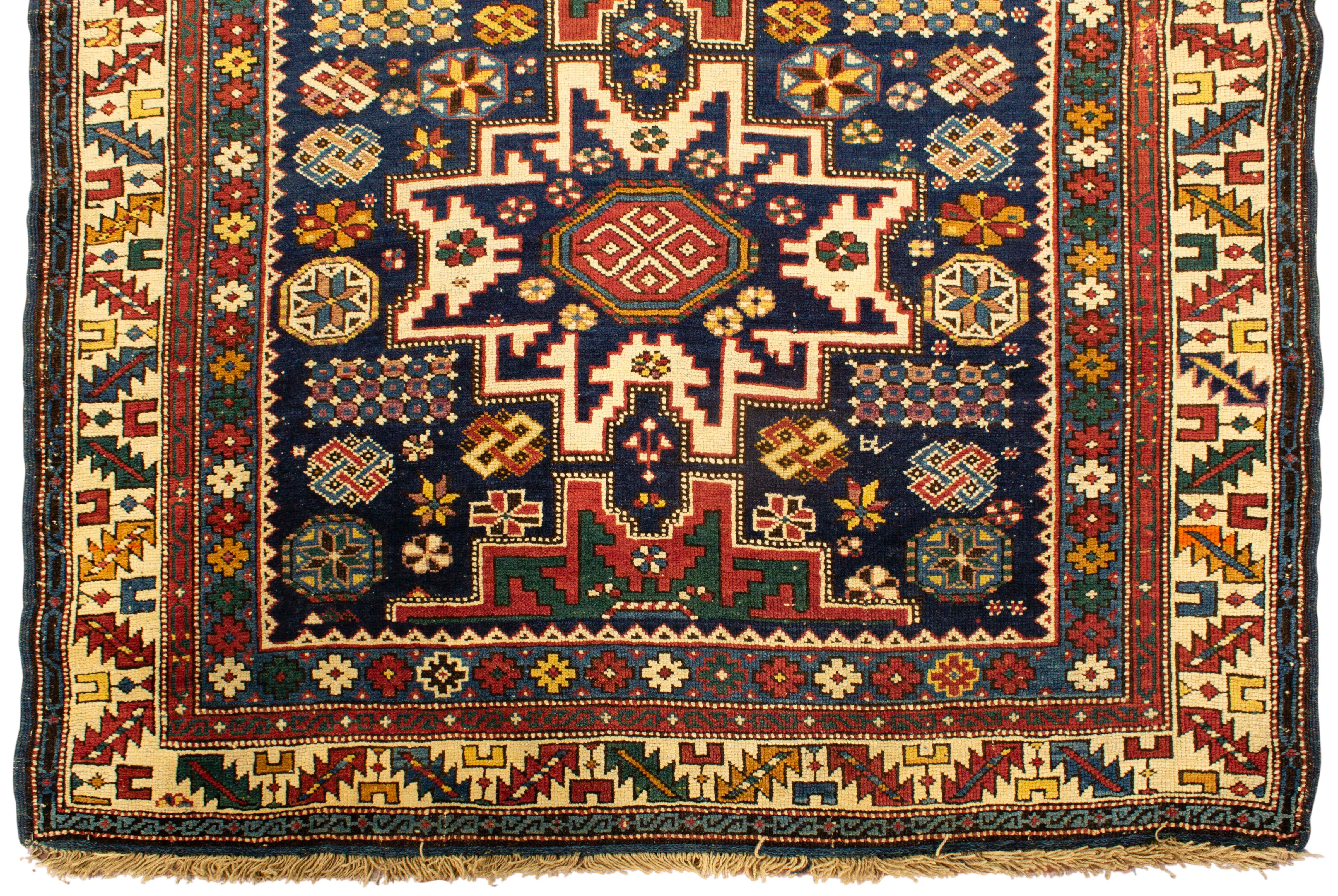 Tapis caucasien antique Lesghi Star vers 1880, le champ central avec les deux motifs d'étoiles distinctifs qui sont l'élément de signature des tapis de cette région, entouré de symboles et de dessins ethniques complétés par de multiples bordures qui