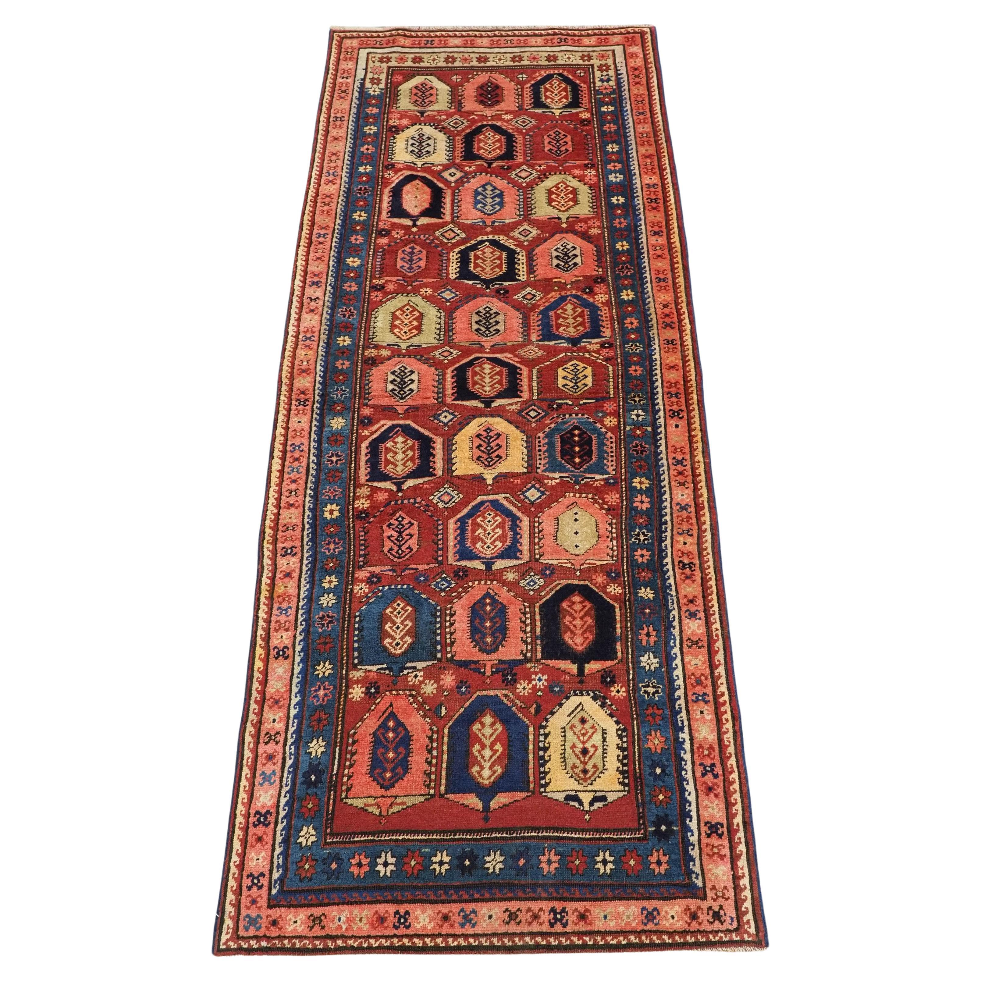 Alfombra larga caucásica antigua con diseño de boteh.  Alrededor de 1900.
