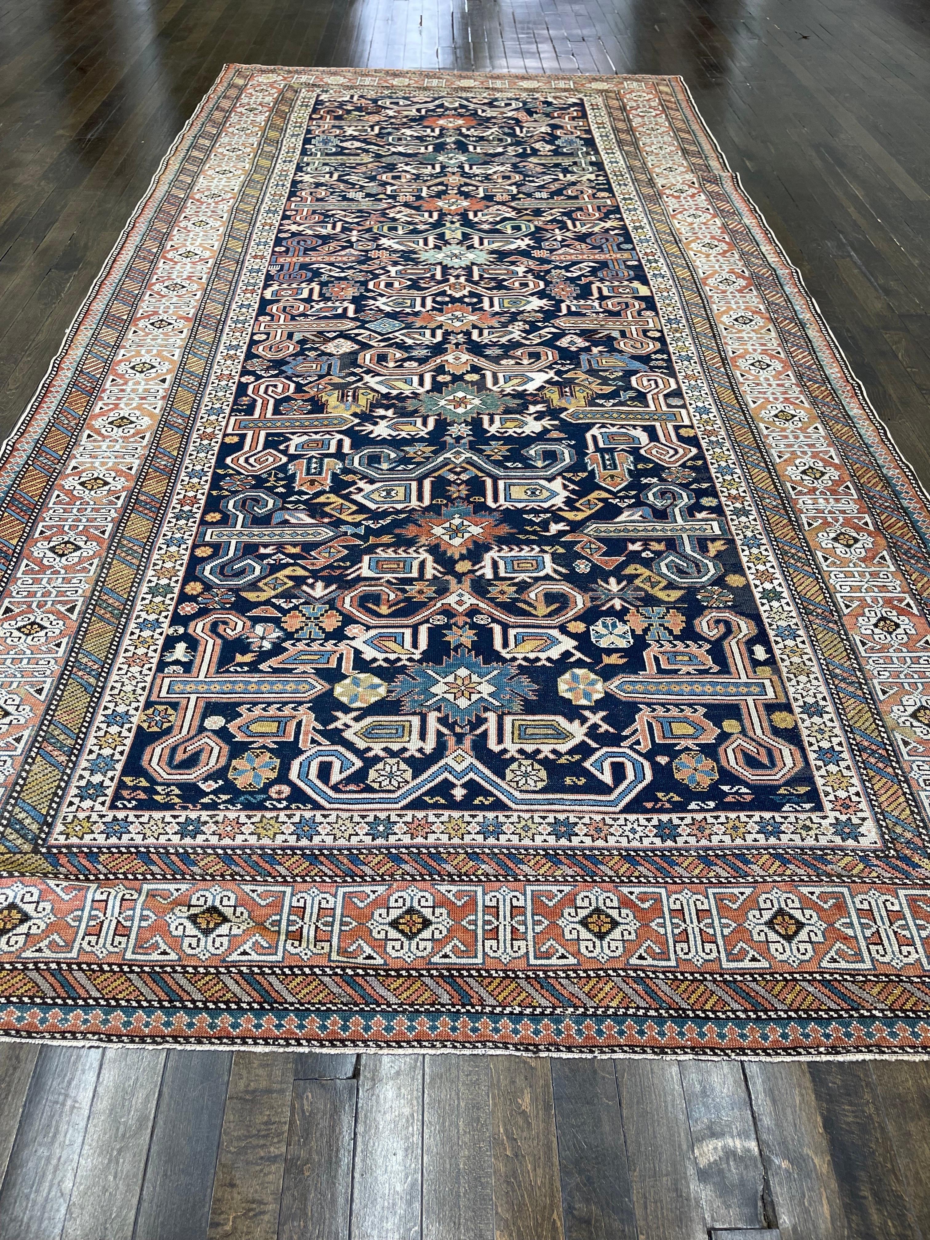 Extremely rare, Perpedil, Kuba district this rug is hand woven in Eastern Caucasus. This tightly woven rug contains nine ram's horns (wurma) in the center of the deep indigo-blue field separated by beautiful red flowers. Four animals frame each