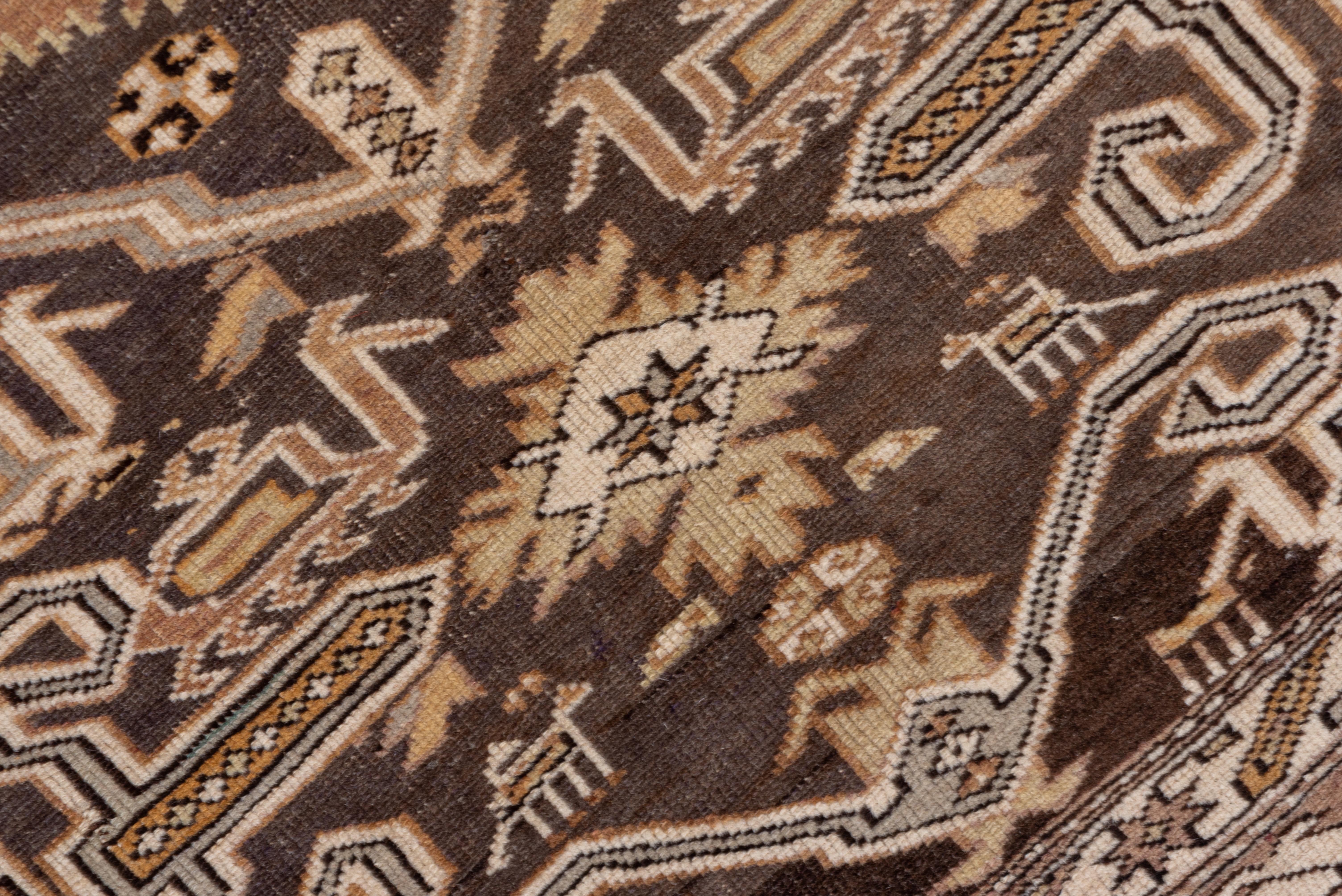 This east Caucasian scatter has the characteristic rams' horns pattern on the abrashed brown field, with peacocks and tiny animals mixed in with larger stars, rosettes and volute V's. The six geometric borders include a keyhole reciprocal, slanted