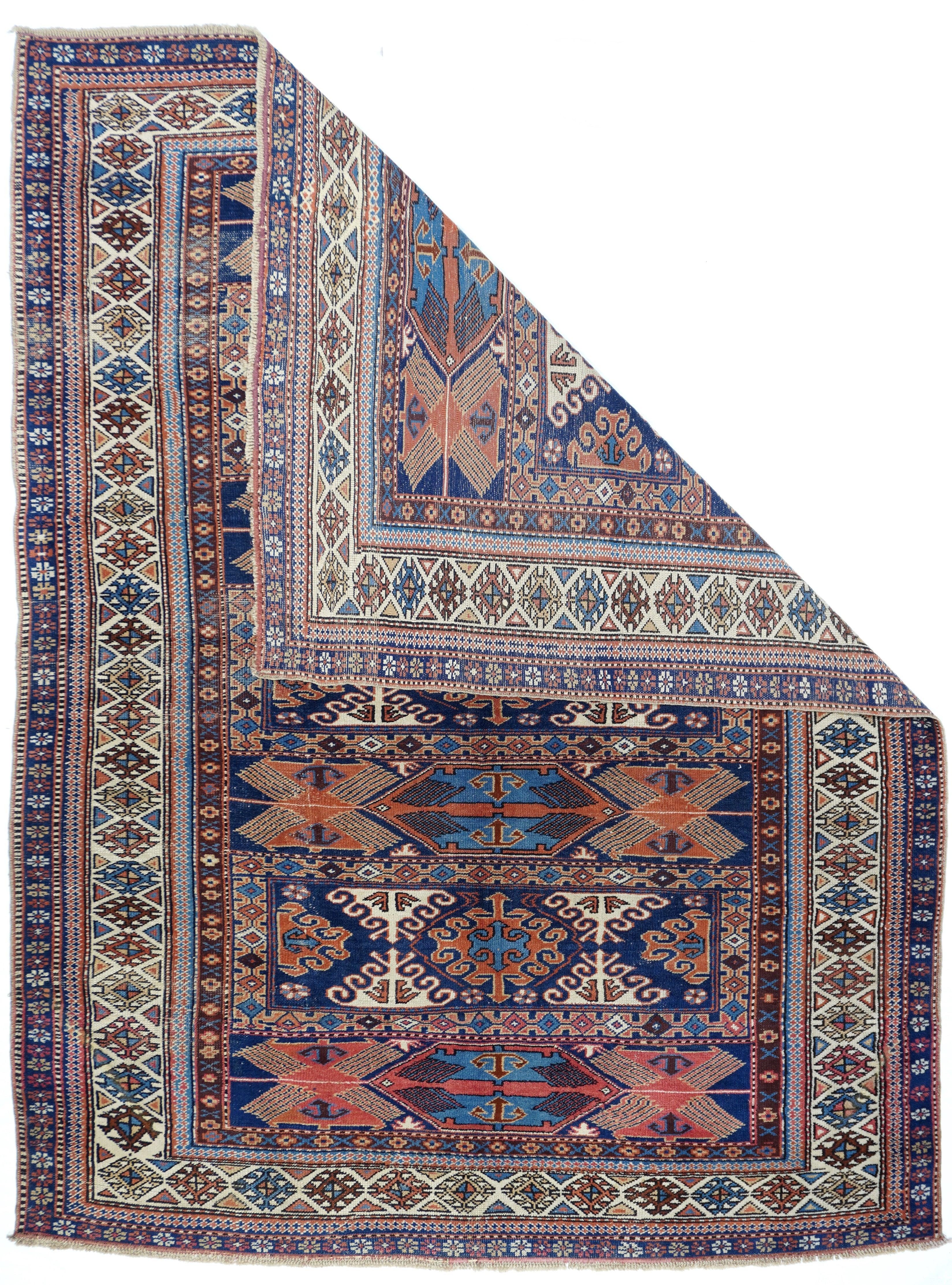 Antique Caucasian Rug 5'5'' x 7'5''. This very rare, probably east Caucasian/west Caspian, scatter in an enlarged soumak bag face design shows seven panels alternating with curly hooked lozenges and triangles within narrow borders, on dark blue