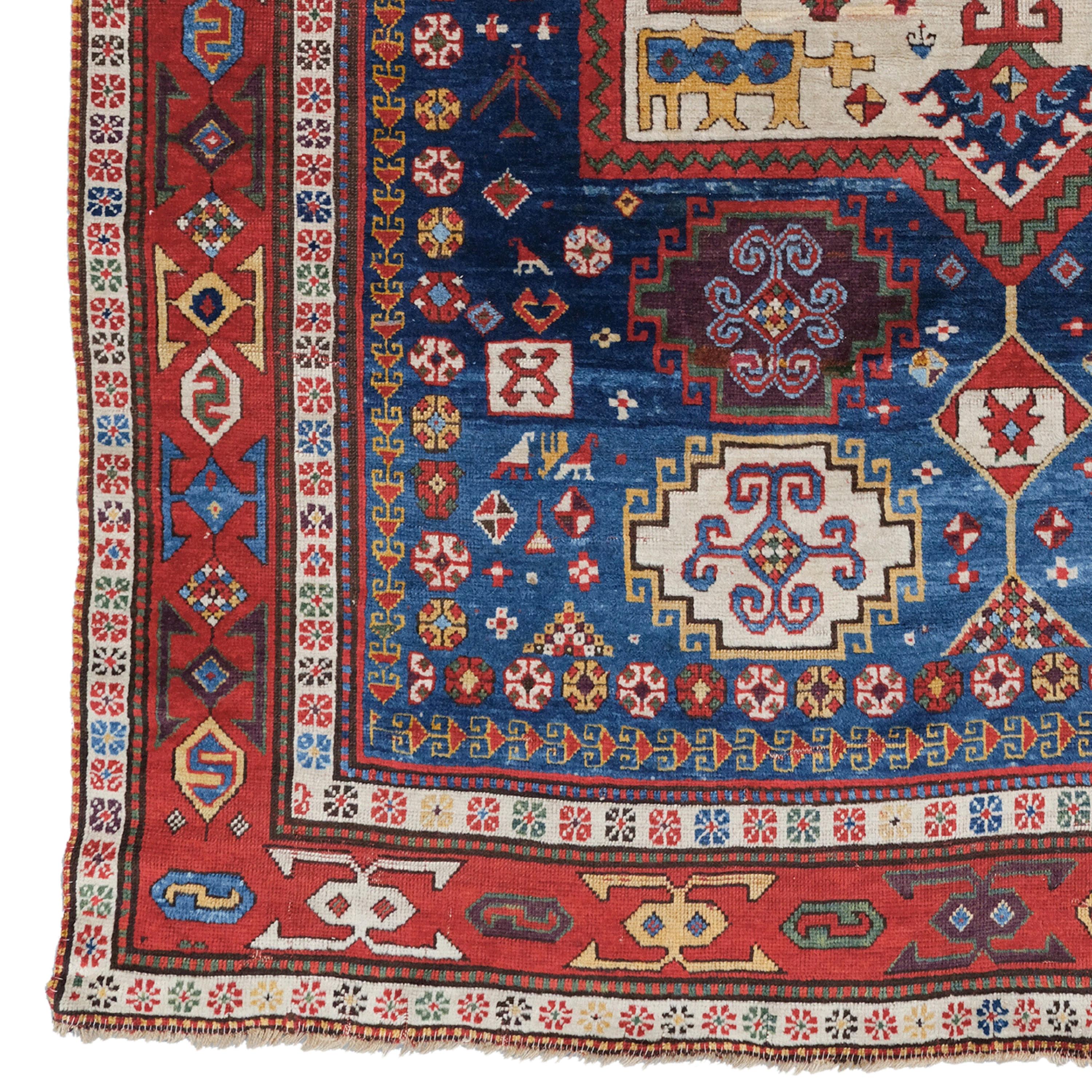Rare Caucasian Rug  Caucasus Rug
Size: 176×224 cm

This wonderful rug is a formerly unpublished addition to a small and rare group of blue-ground Caucasian rugs whose design is dominated by a prominent decahedral gabled ivory medallion. The overall