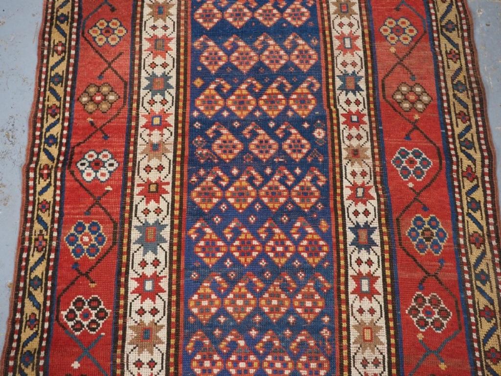 Antiker kaukasischer Teppich mit kleinem Format und wiederholtem Boteh-Muster
CIRCA 1890

Ein attraktiver kleiner Teppich mit einem mittelblauen Feld, das mit Reihen kleiner Boteh gefüllt ist. Die Innenbordüre hat einen elfenbeinfarbenen Grund mit