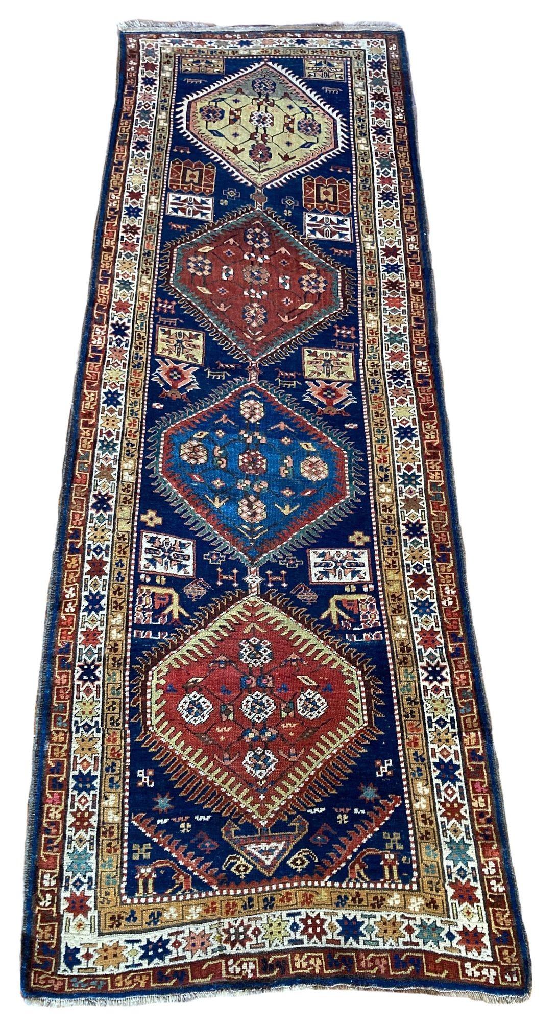 A fabulous antique runner, handwoven in the Caucasus mountains of southern Azerbaijan circa 1900. The design features 4 medallions on a navy blue field and ivory border. Lots of lovely secondary colours and a couple of animals if you can spot